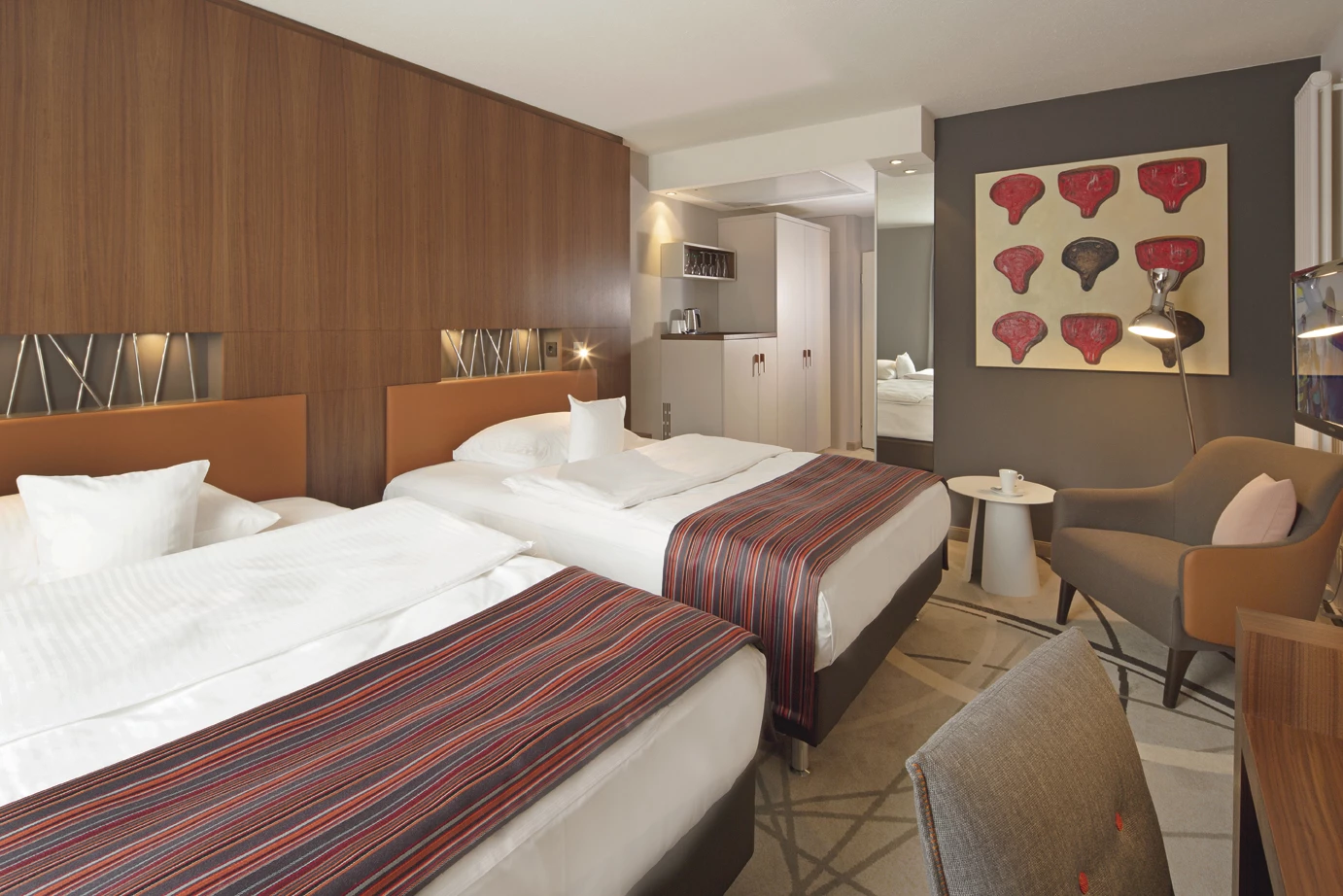 Zimmerbeispiel mit Doublequeensizebetten und Kitchenette und Sitzecke Mövenpick Münster