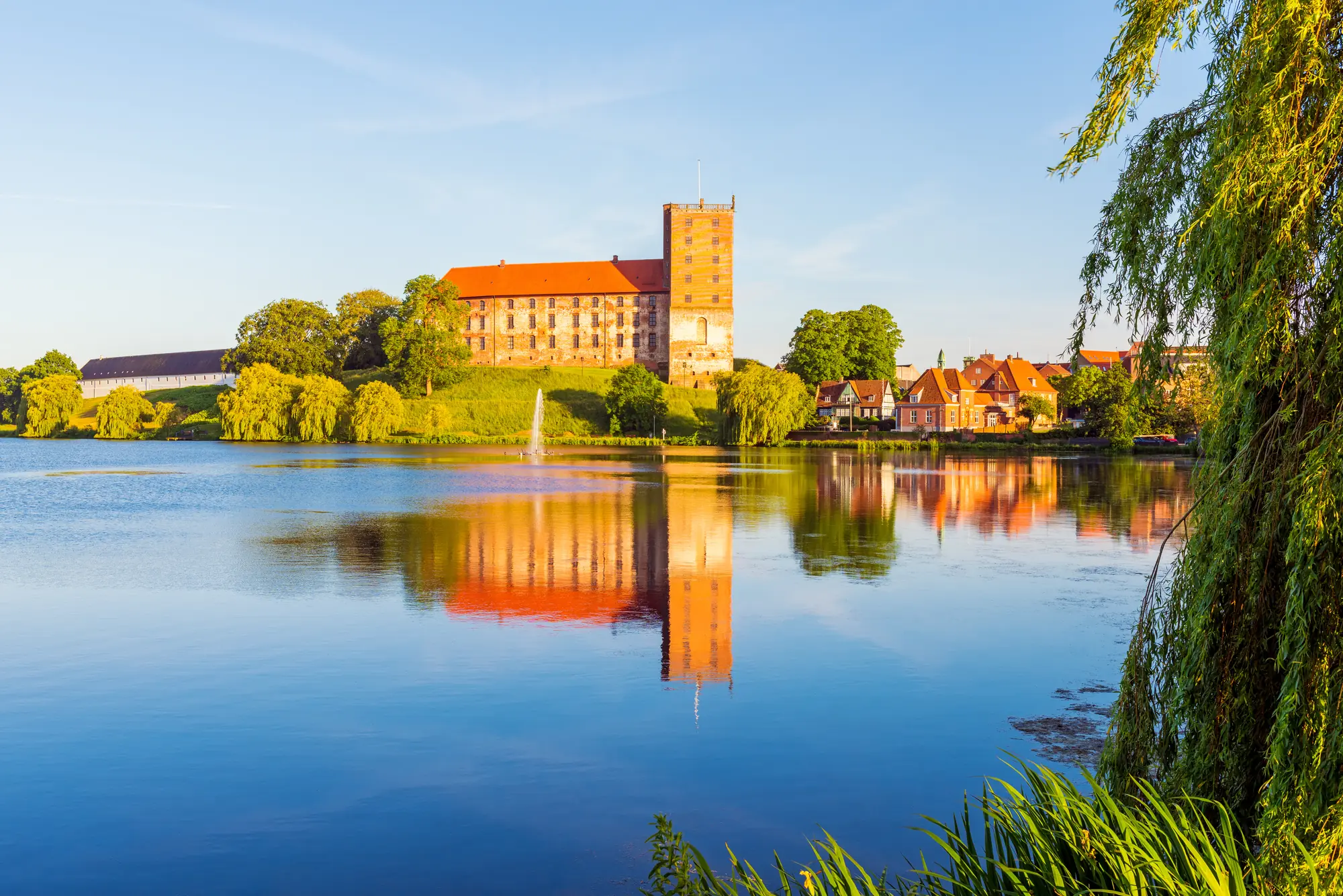 Blick vom Wasser auf das Schloss Kolding in der Nachmittagssonne in Kolding auf Jütland