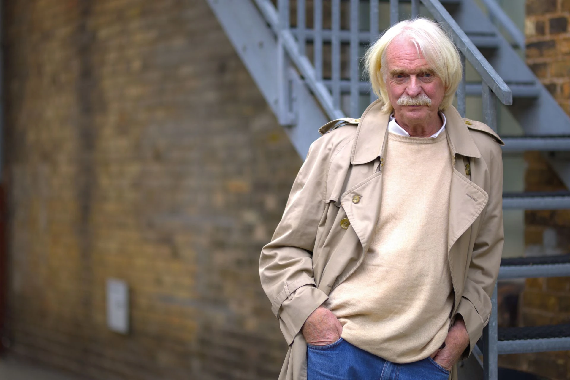 Bild von Axel Wacherloft angelehnt an ein Treppengeländer aus Metall an einer Häuserwand