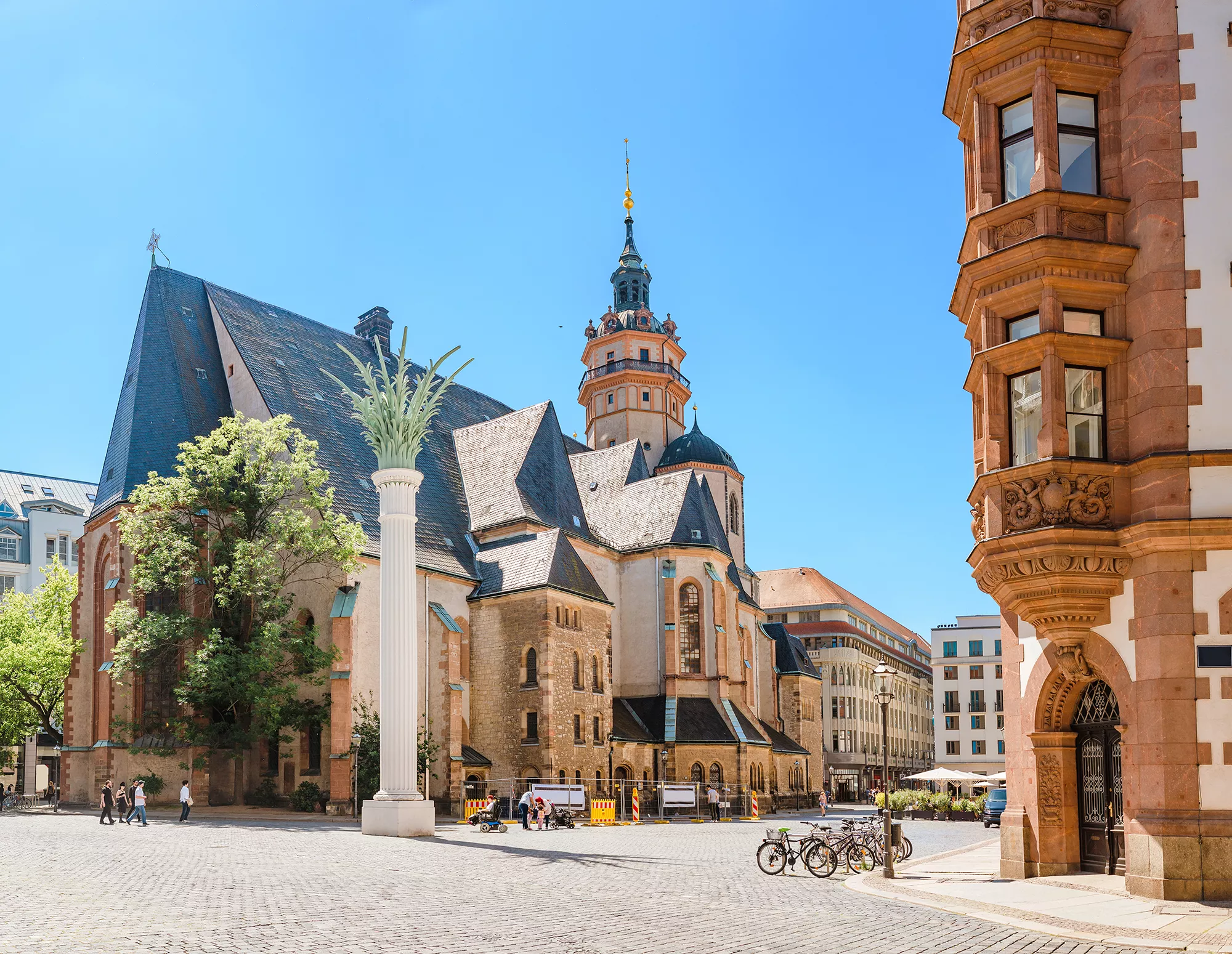 Die Nikolaikirche in Leipzig mit weisser Nikolaisäule davor