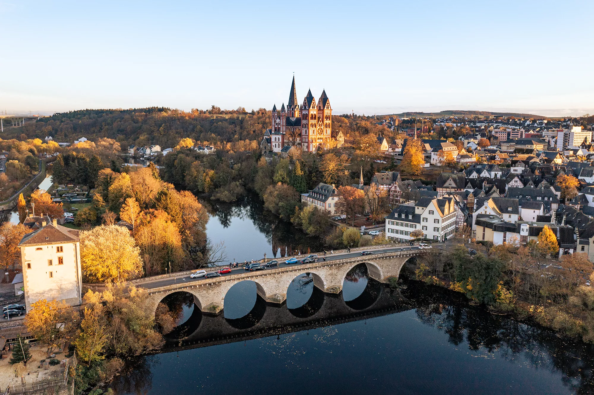 Sicht von oben auf den Fluss Lahn, der historischen Brücke und Stadtzentrum Limburg mit Limburger Dom in der Abenddämmerung.