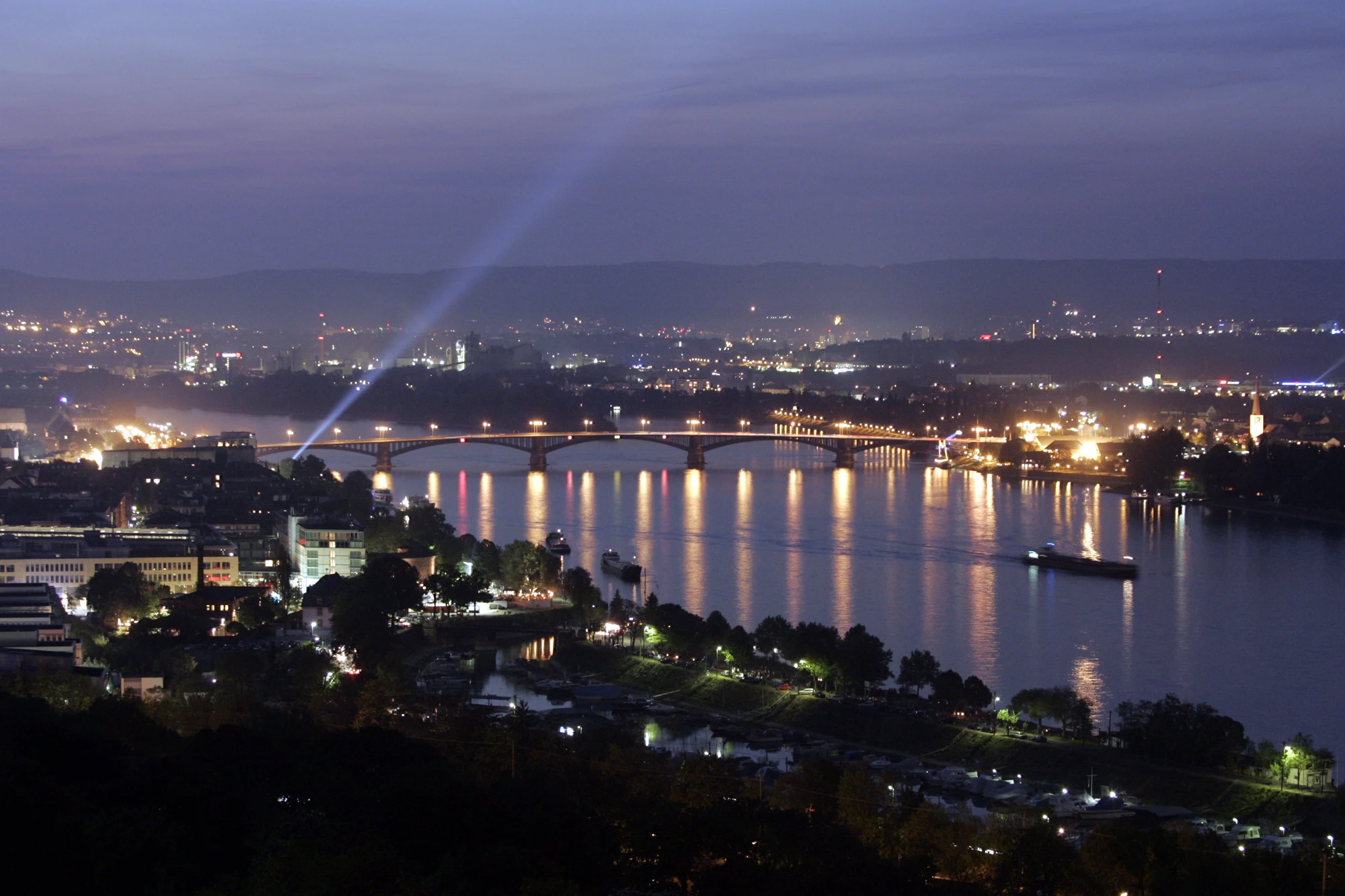 neblige Abendszene von Mainz mit dem Rhein und Lichtermeer