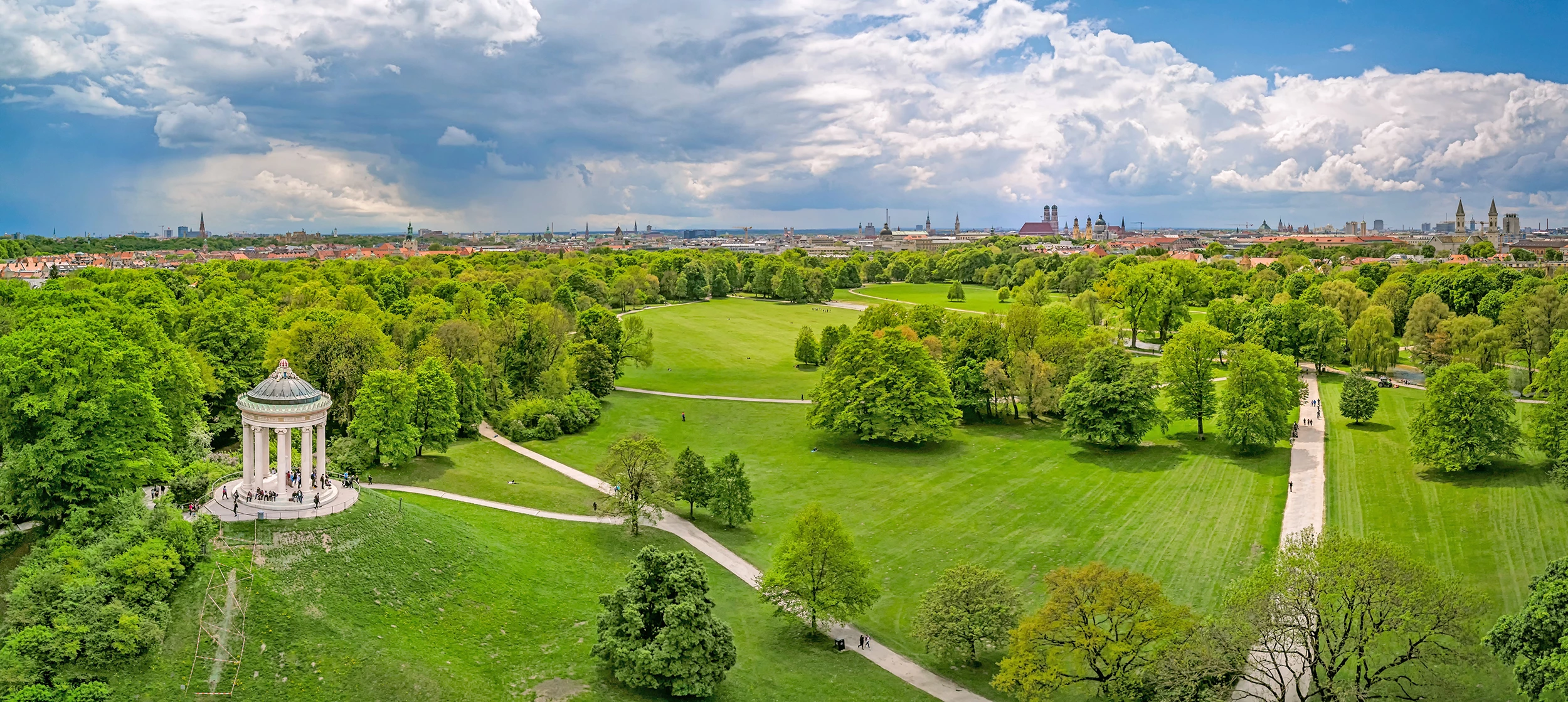 Englischer Garten von oben mit Stadt im Hintergrund während des Kurzurlaubs in München