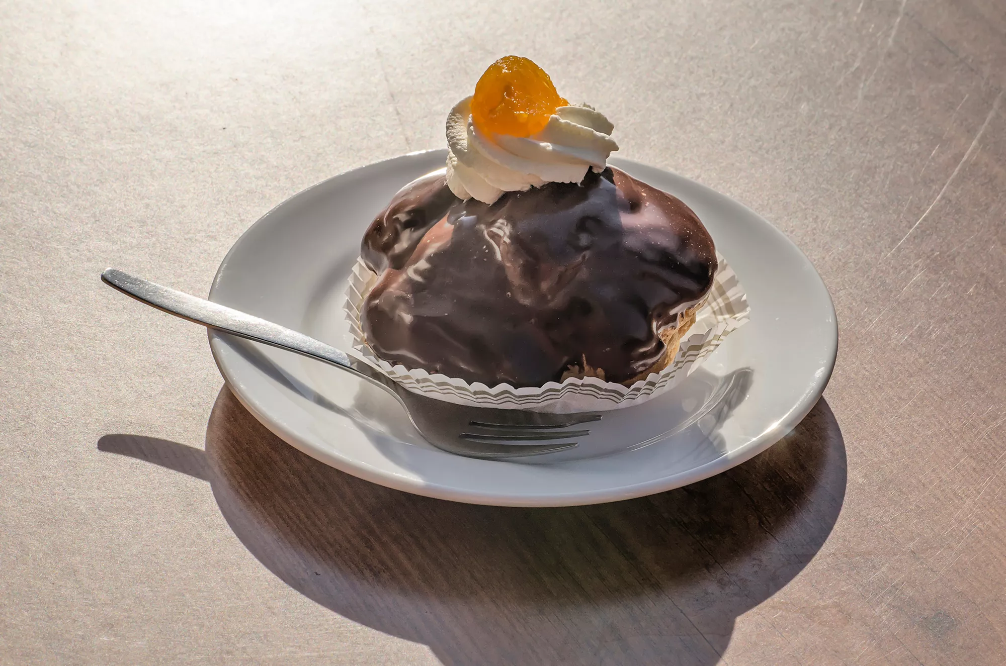 Eine Nahaufnahme von Bossche Bollen, der berühmten Schokoladenspezialität aus Hertogenbosch. Die süßen Köstlichkeiten, mit einer luftigen Vanillecremefüllung, sind kunstvoll mit einer glänzenden Schokoladenglasur überzogen. Die detailreiche Darstellung betont die verführerische Textur und das appetitliche Aussehen dieser regionalen Delikatesse, die für ihre einzigartigen Aromen und die traditionelle Herstellung geschätzt wird.