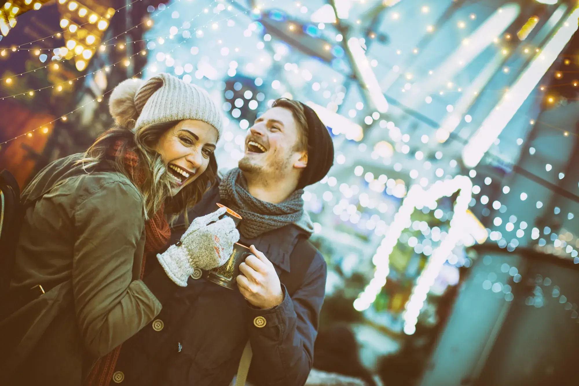 Lachendes Paar auf dem Weihnachtsmarkt