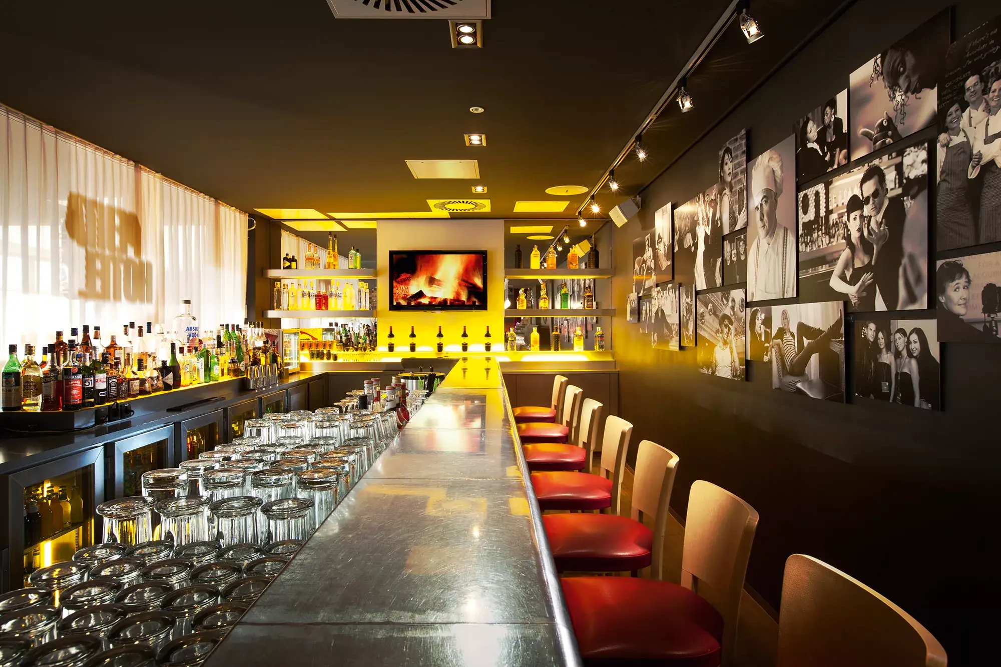 Lange Bar im Penta Hotel Eisenach mit schwarz-weiß Fotografien und roten Hockern
