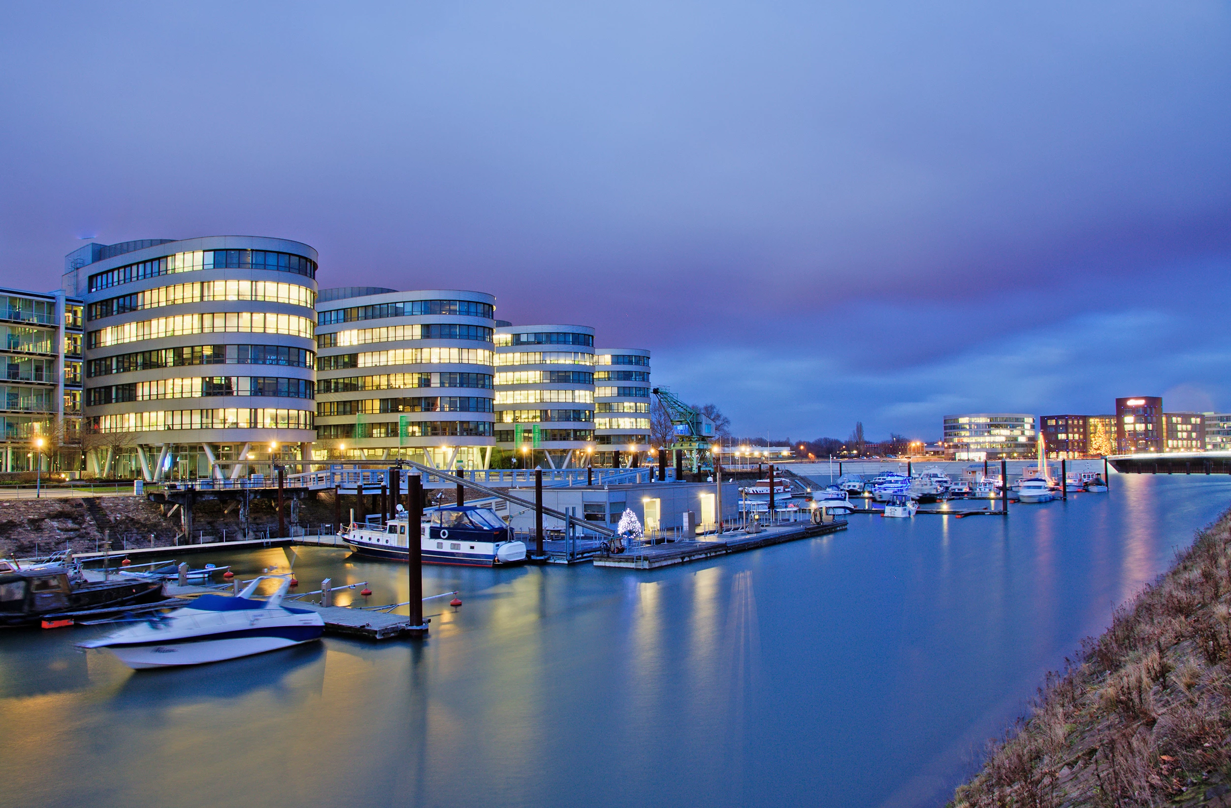 Blick auf den Yachthafen vor spektakulärer Architektur des Innenhafen Duisburg in der Nacht