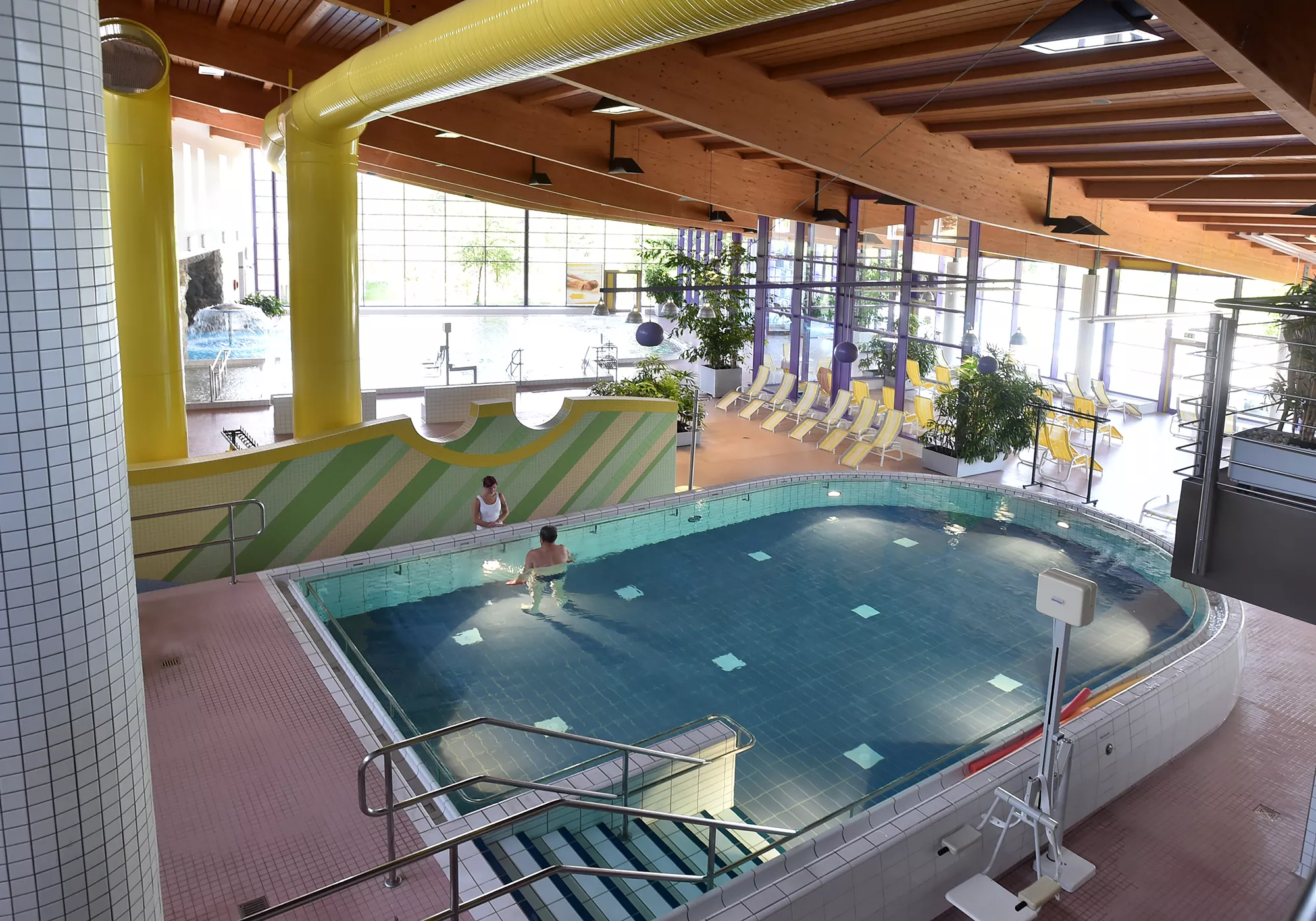 Ansicht von Oben in den in hellen Farben und modern eingerichteten Warmbad Innenpool mit zwei Wasserbecken im Santé Royale Wolkenstein