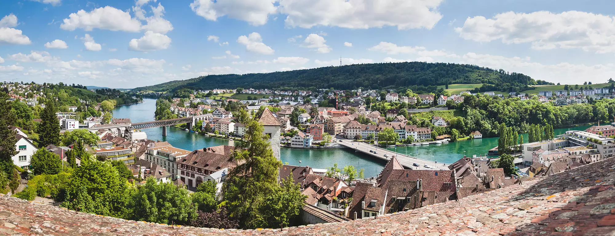 sonniger Panoramablick bei einer Reise nach Schaffhausen mit Hotel - der Rhein im türkis schlängelt sich durch die Stadt