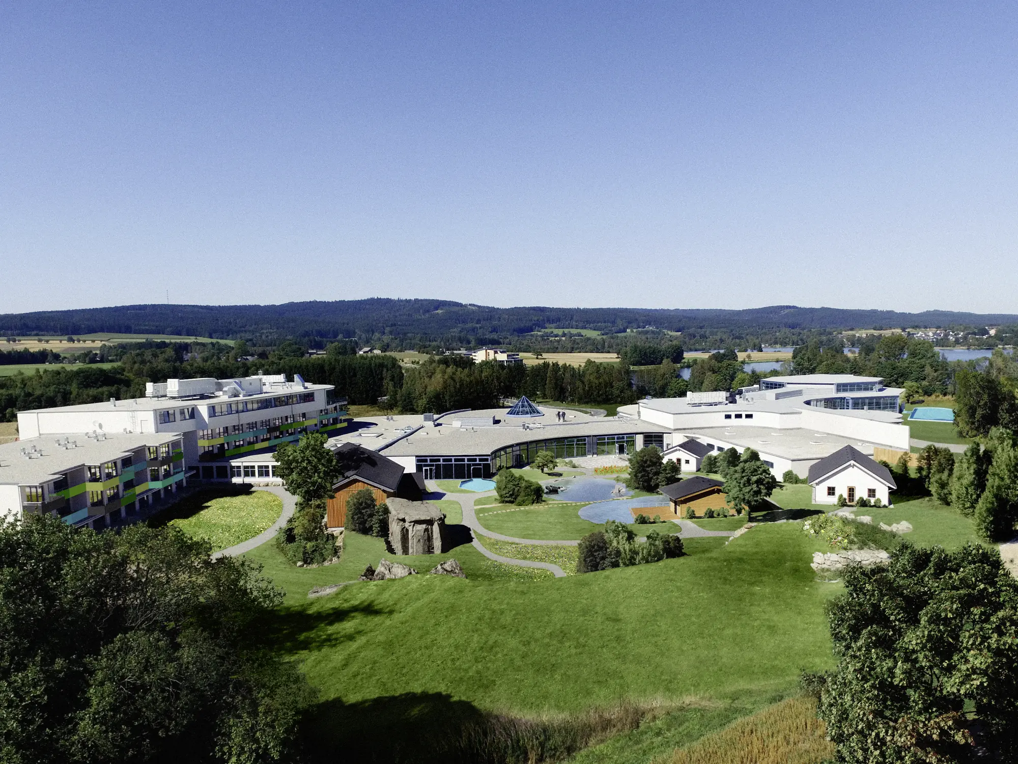Panoramablick auf die gesamte Anlage des Siebenquell Therme Gesundheits- und Wellnesshotel inmitten von sanften Hügeln des umgebenen Fichtelgebirge.