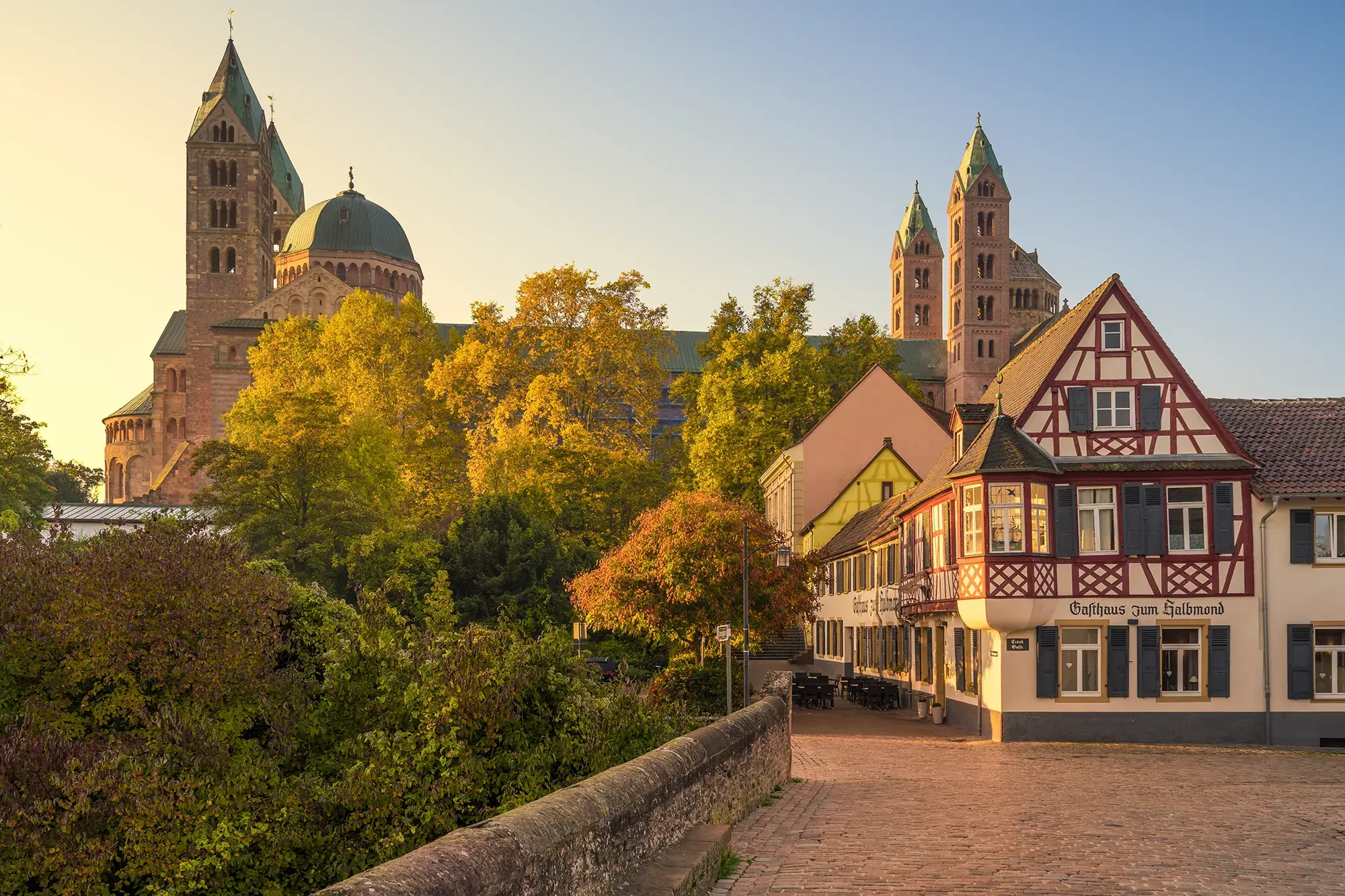 Blick auf das in einem historischen Fachwerkhaus befindliche Gasthaus zum Halbmond in Speyer und im Hintergrund der große Dom zu Speyer