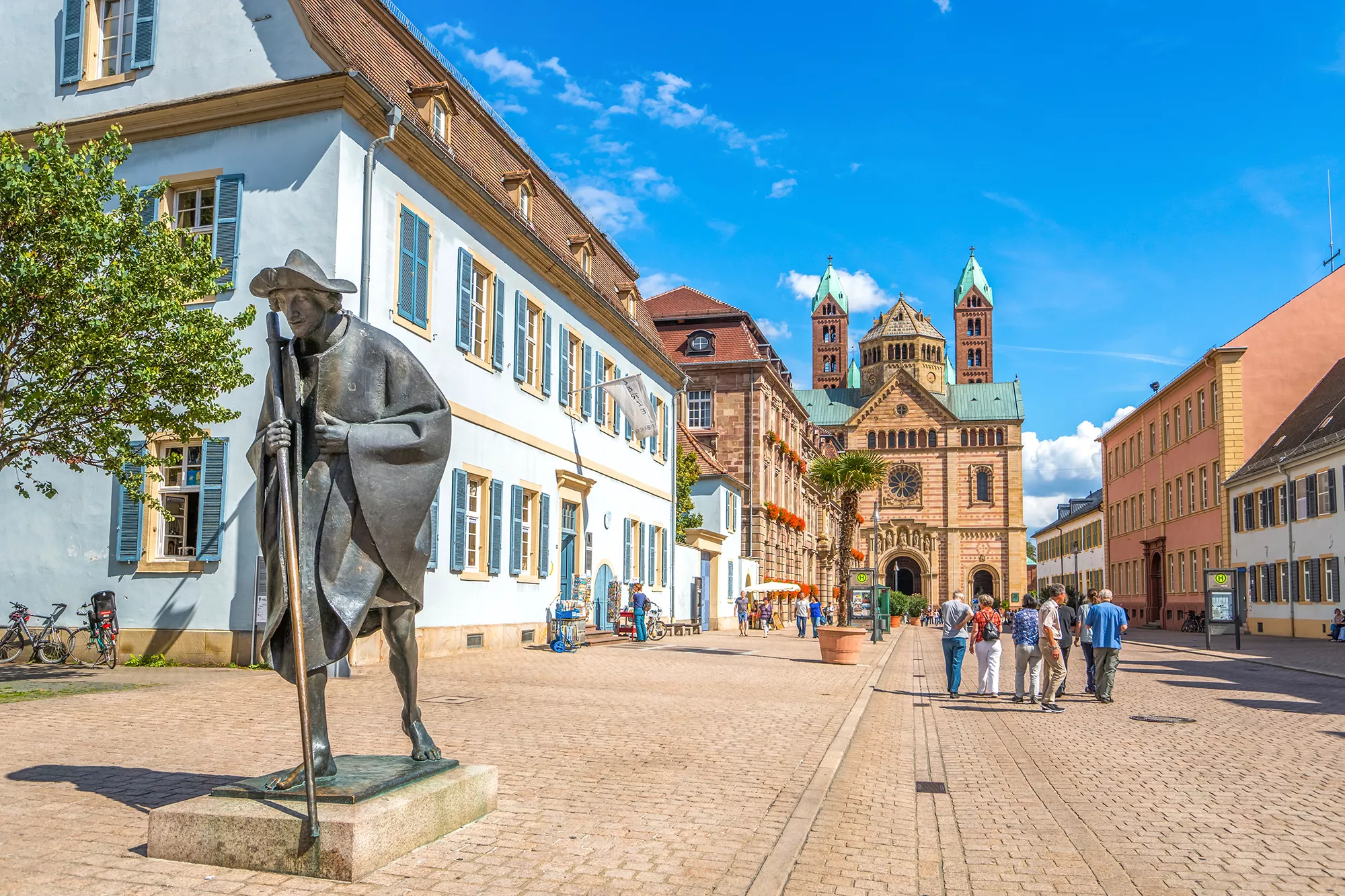 Blick in eine Fußgängerstraße im Stadtzentrum Speyer mit restaurierten Häusern und einer großen Kirche am Ende