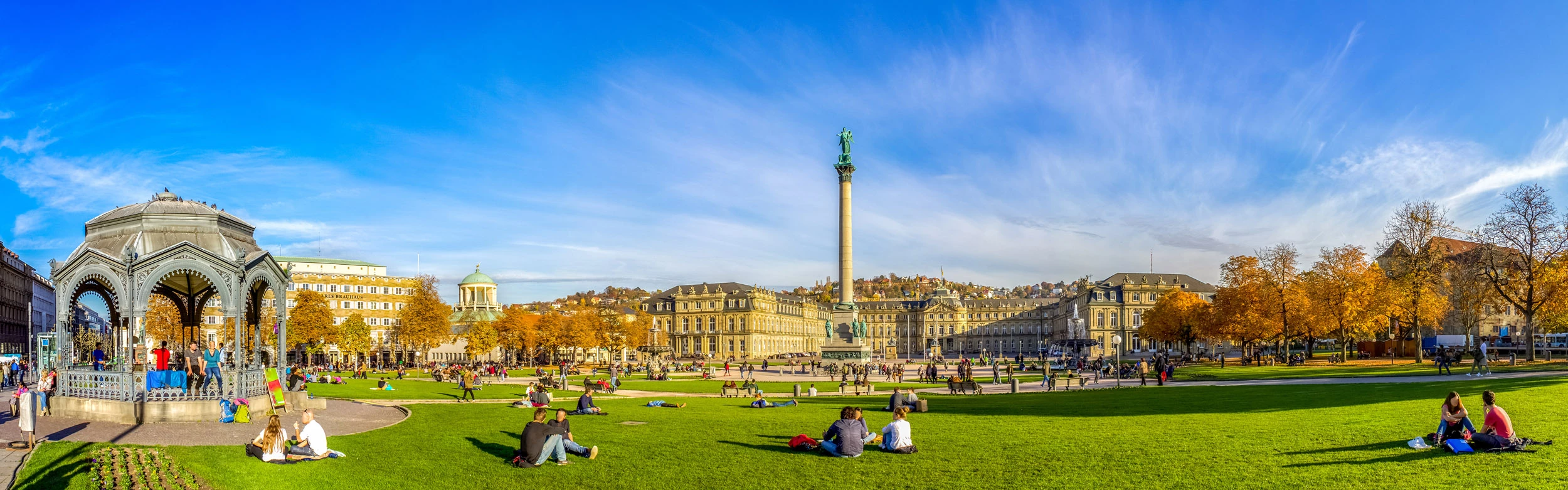Neues Schloss und Schlossplatz in Stuttgart im Sommer, Menschen sitzen im Park und gehen spazieren