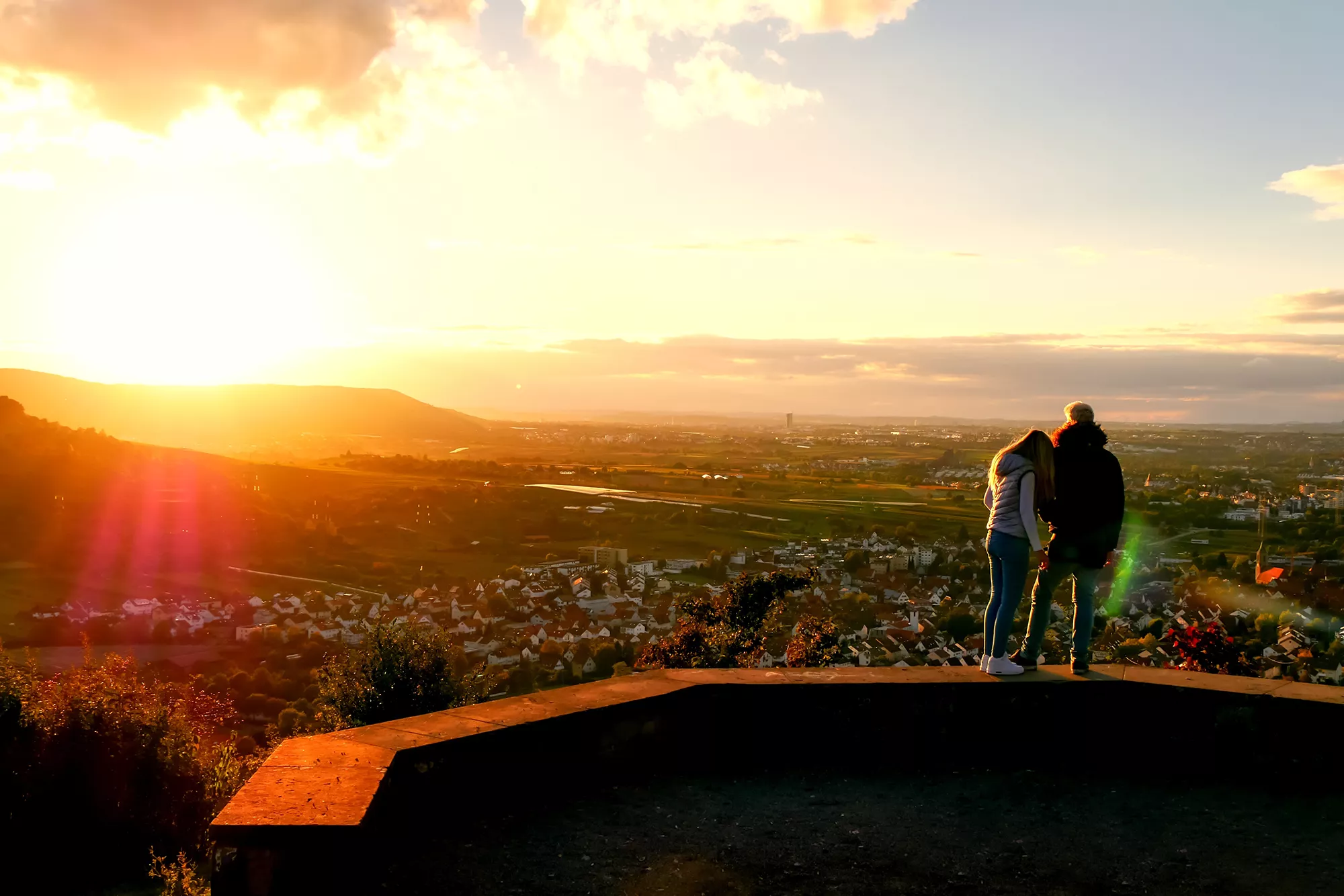 Pärchen genießt den Panoramablick über die Stadt bei Sonnenuntergang bei einer Städtereise in Stuttgart
