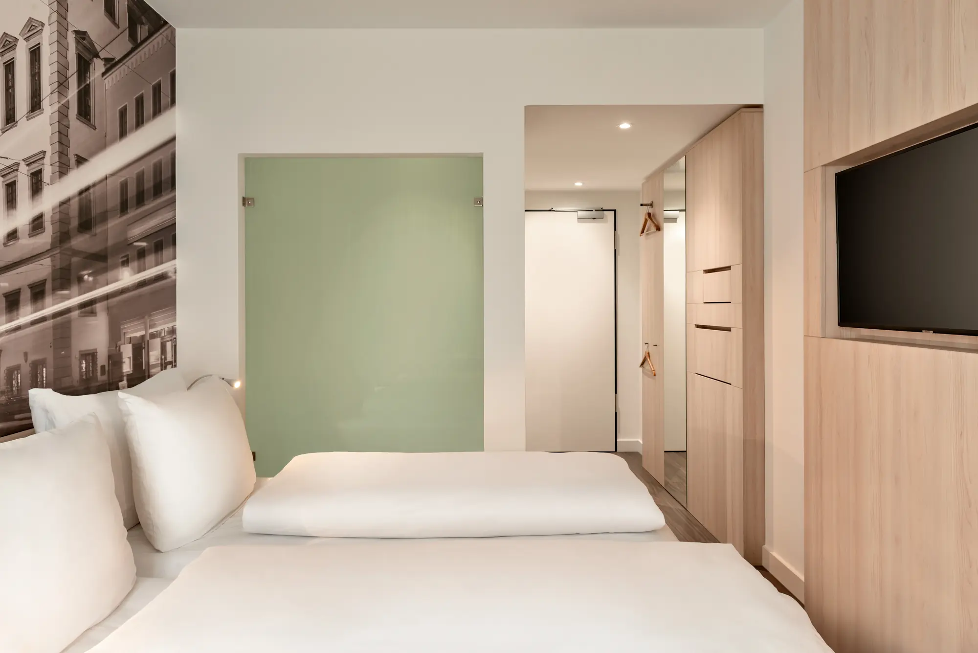 Zimmerbeispiel im Super 8 by Wyndham Hotel Koblenz mit Doppelbett mit Blick zum Flur und Badezimmer