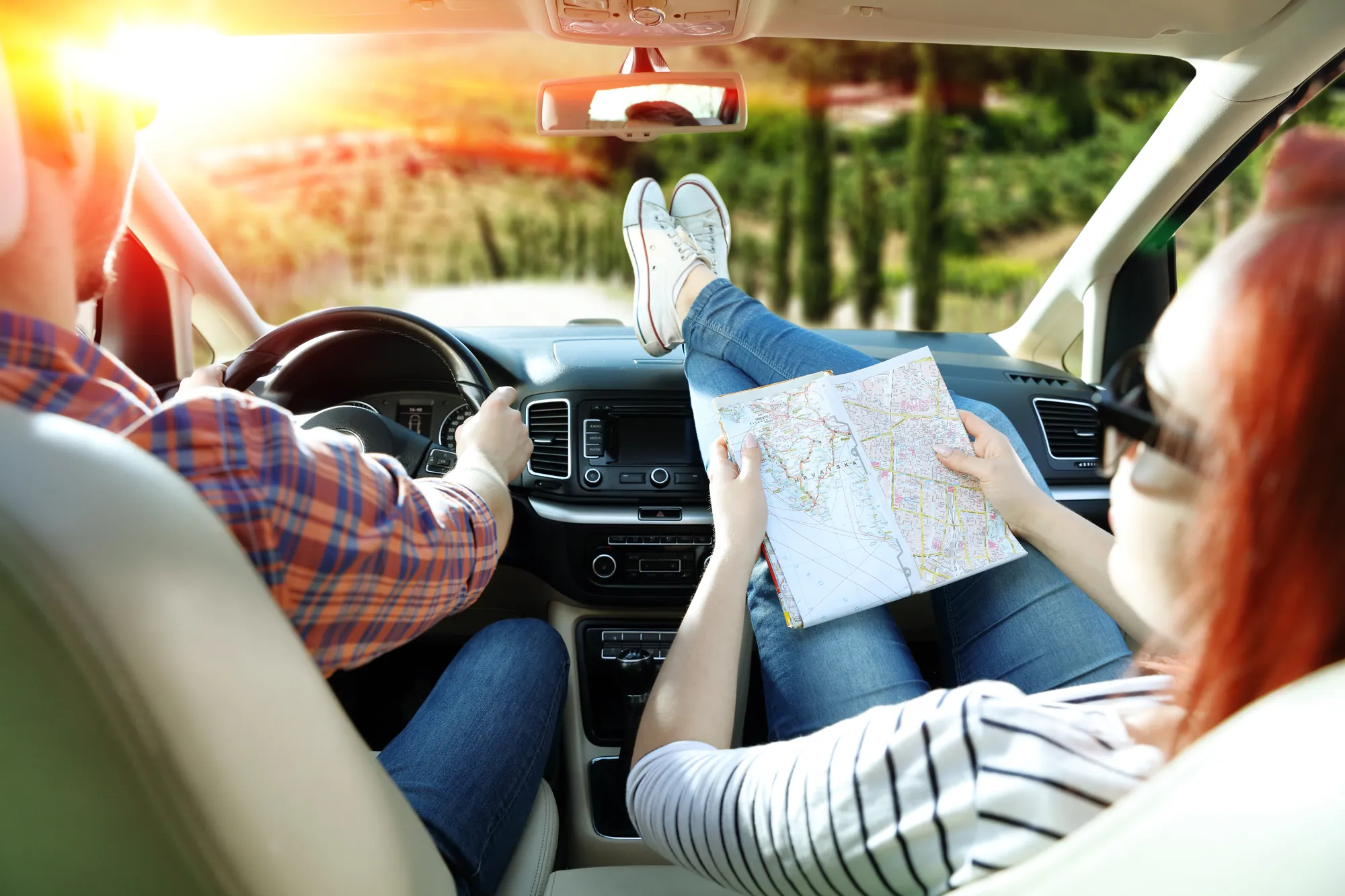 Pärchen unterwegs im Auto mit Landkarte