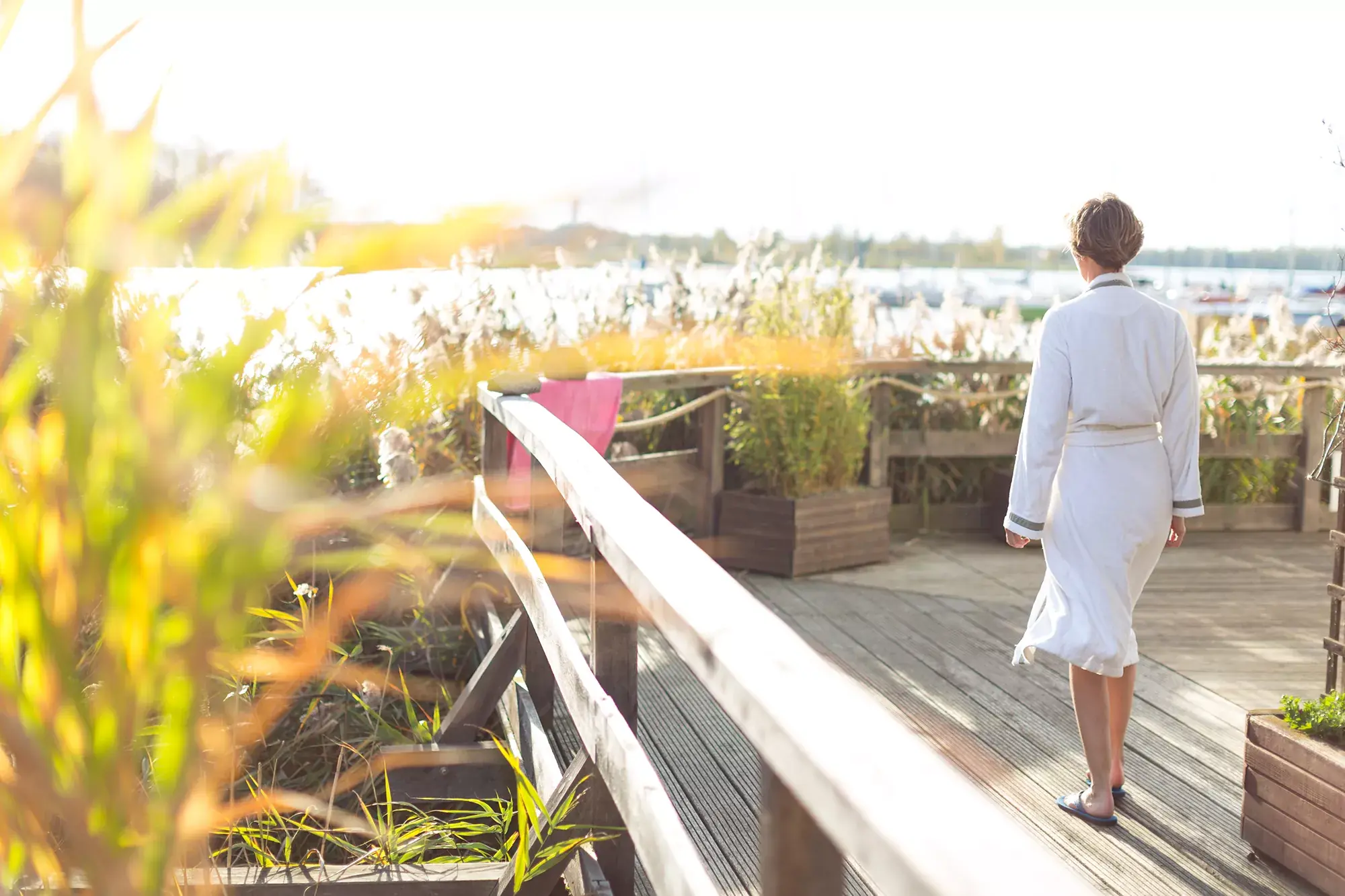 Frau im Bademantel auf der Terrasse ihres Wellness Hotels