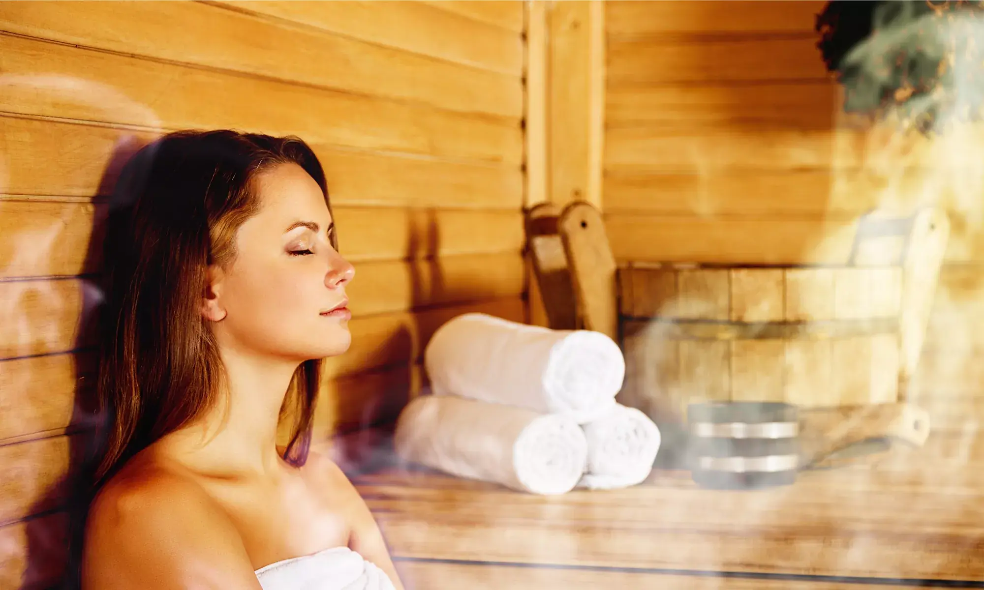 Junge Frau in der dampfenden Sauna im Wellness Urlaub