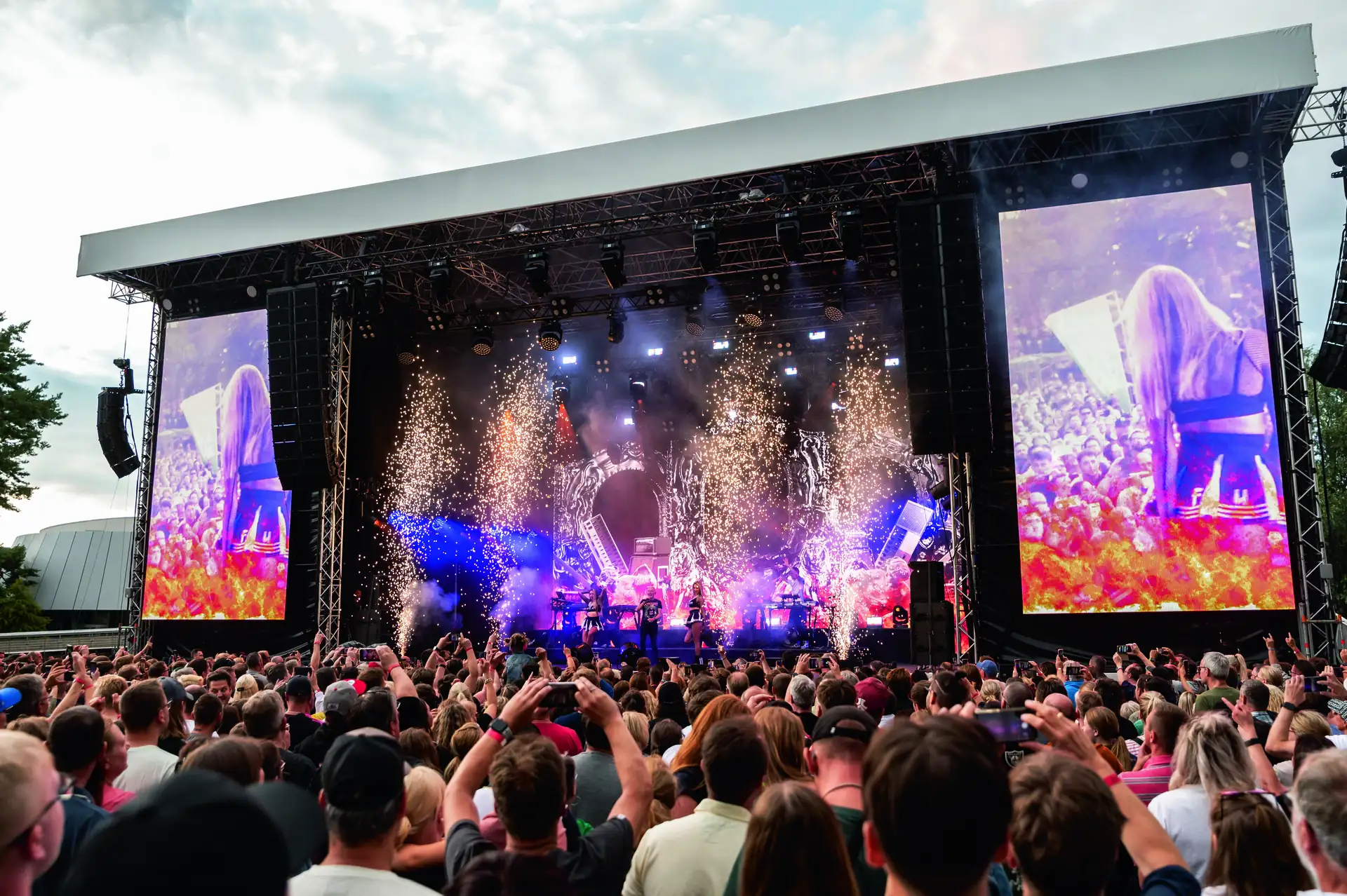 Autostadt Sommerfestival 2024 - Konzert von Scooter: Große Bühne bei einem Open-Air-Konzert mit Pyrotechnik und vielen Zuschauern, die das Event mit ihren Handys filmen