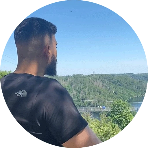Profilbild von Burak B. - junger Mann mit einer breiten Statur schaut auf die Landschaft