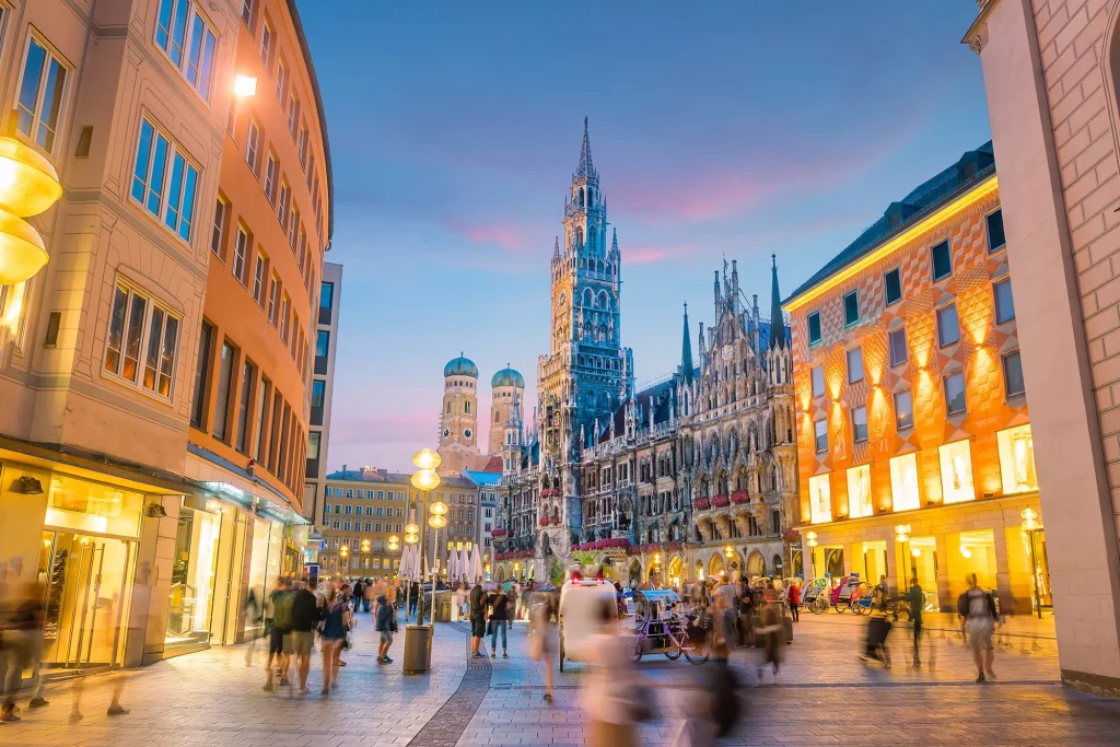 Marienplatz in der Abenddämmerung und im Hintergrund ist die Marienkirchen zu sehen bei einer Reise Bahn mit Hotel