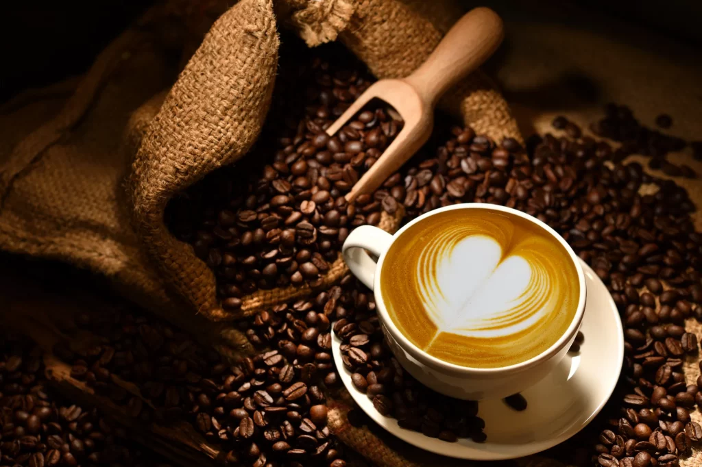 Cappuccino mit Herzmilchschaummuster auf Kaffeebohnen - Das lernen Sie beim Barista Kurs