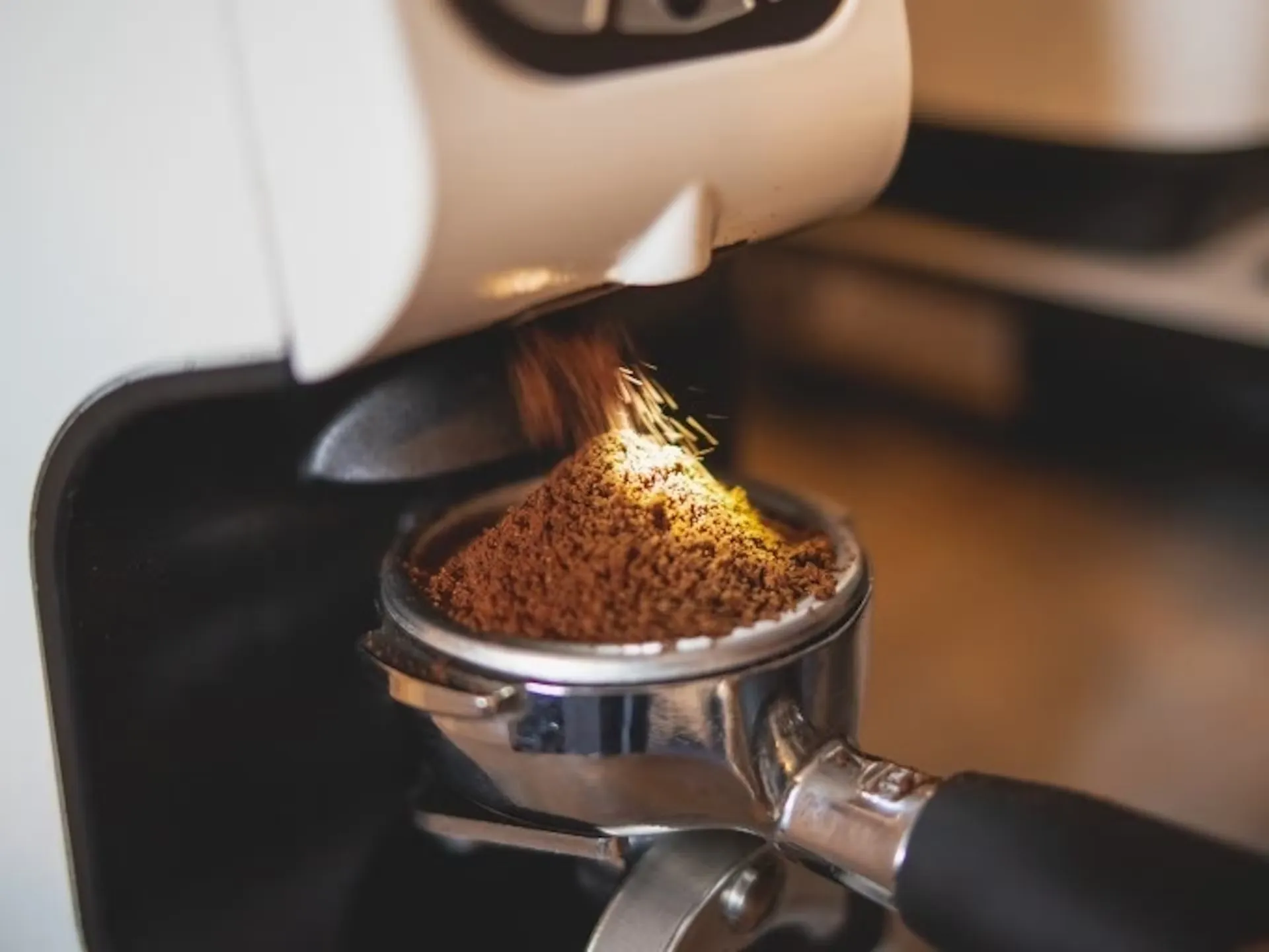 Mahlprozess des Kaffees - der Siebträger füllt sich mit Kaffeemehl auf dem Barista Kurs