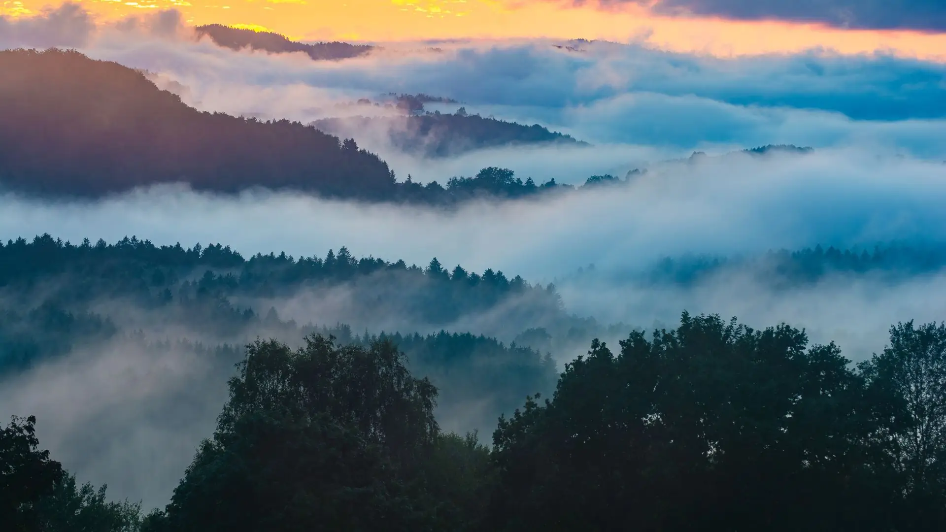 Nebel über den Bergen während des Sonnenuntergangs