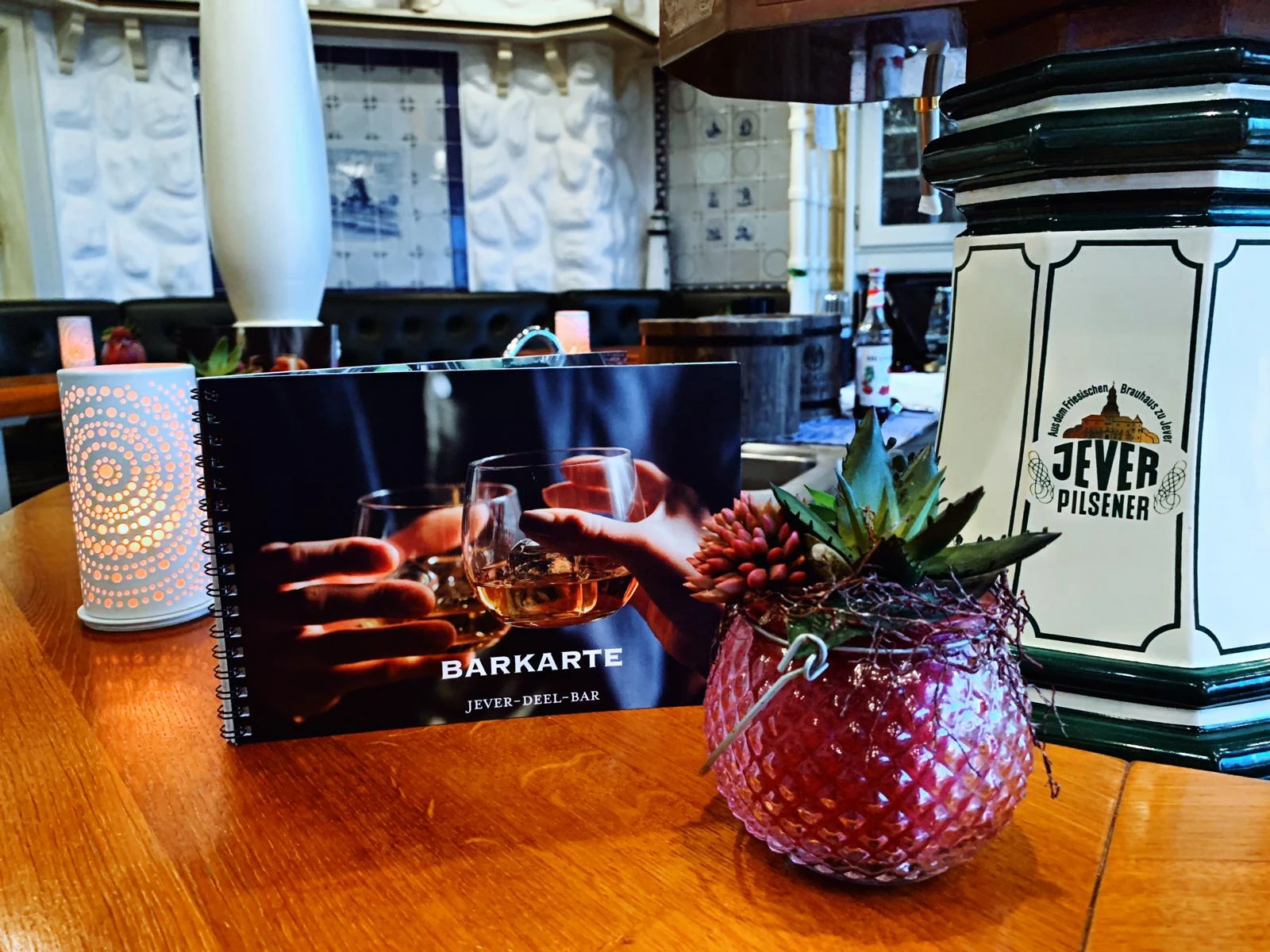 Tisch mit Karte und Blumengesteck in der Jever Deel Bar