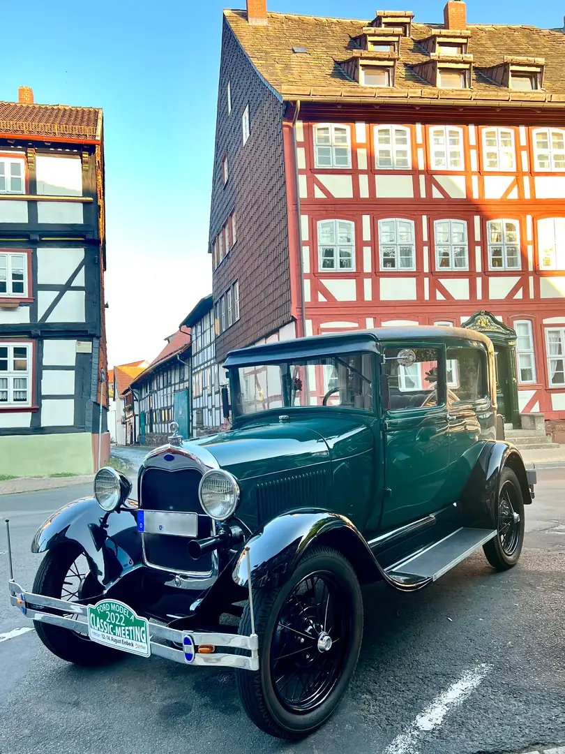 grünlich lackierter Oldtimer vor Fachwerkkulisse