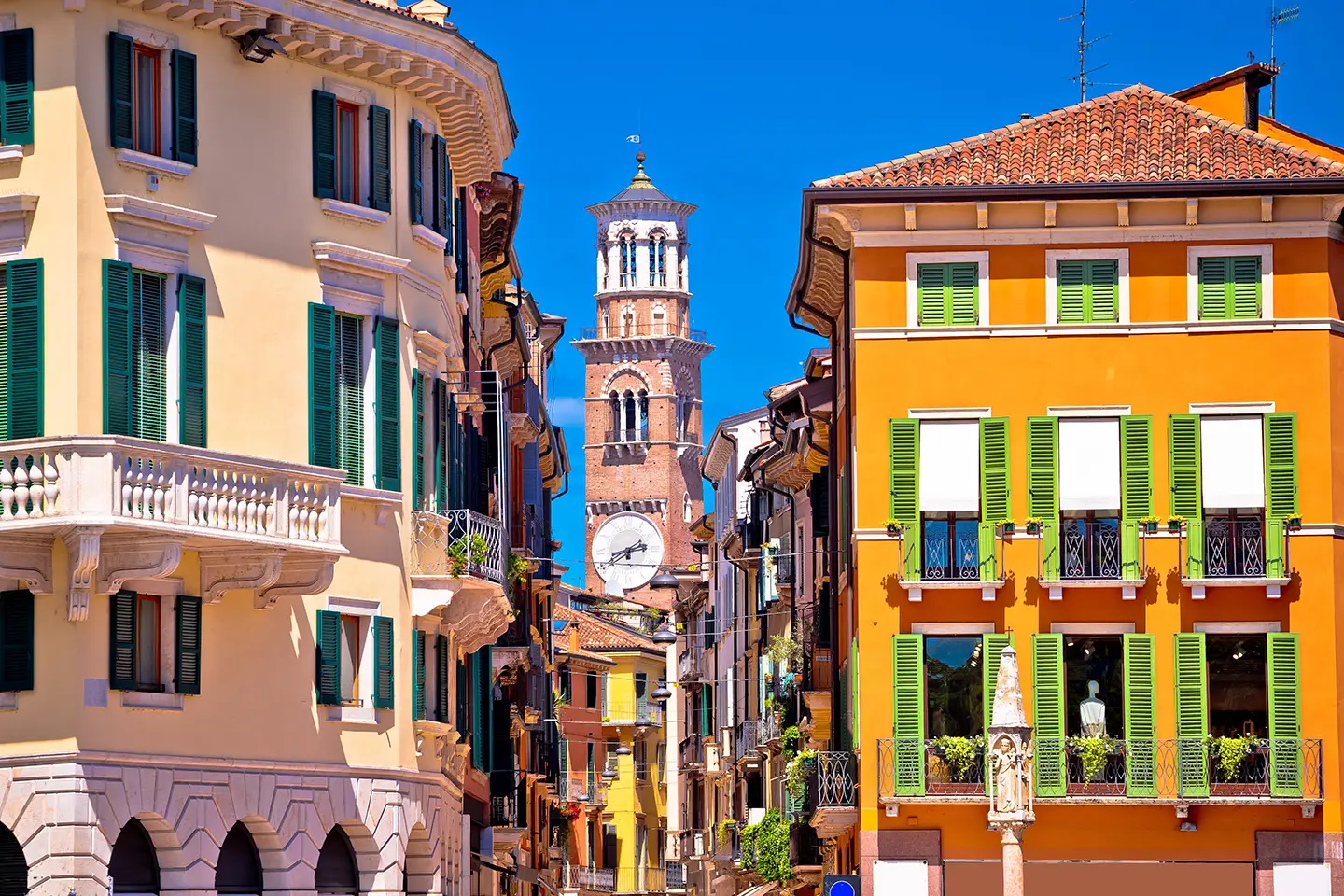 Blick in die Via Mazzini an einem sonnigen Tag, gesäumt von eleganten Geschäften und belebten Cafés. Die helle Atmosphäre und die geschäftige Fußgängerzone verleihen der Straße einen einladenden Charme.