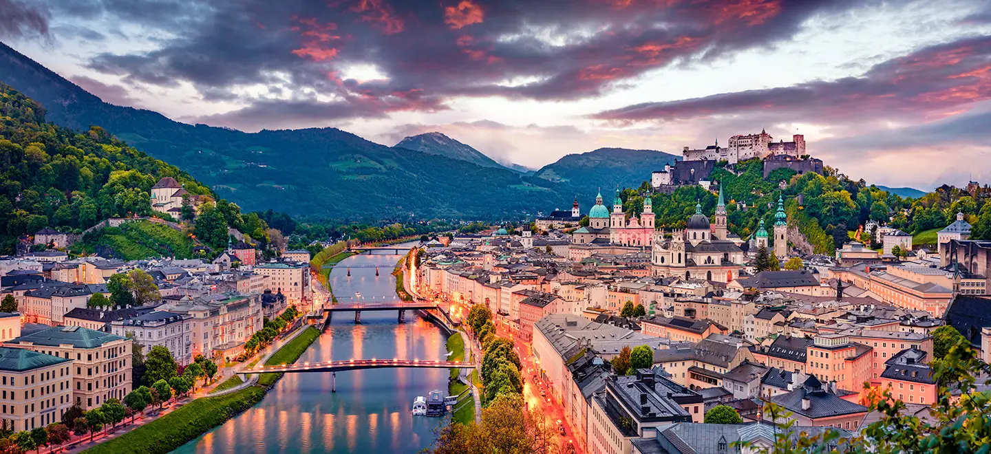 Abendlicher Panoramablick bei einer Städtereise Salzburg bei Bahn und Hotel mit dem Fluss Salzach, Altstadt und Festung Hohensalzburg
