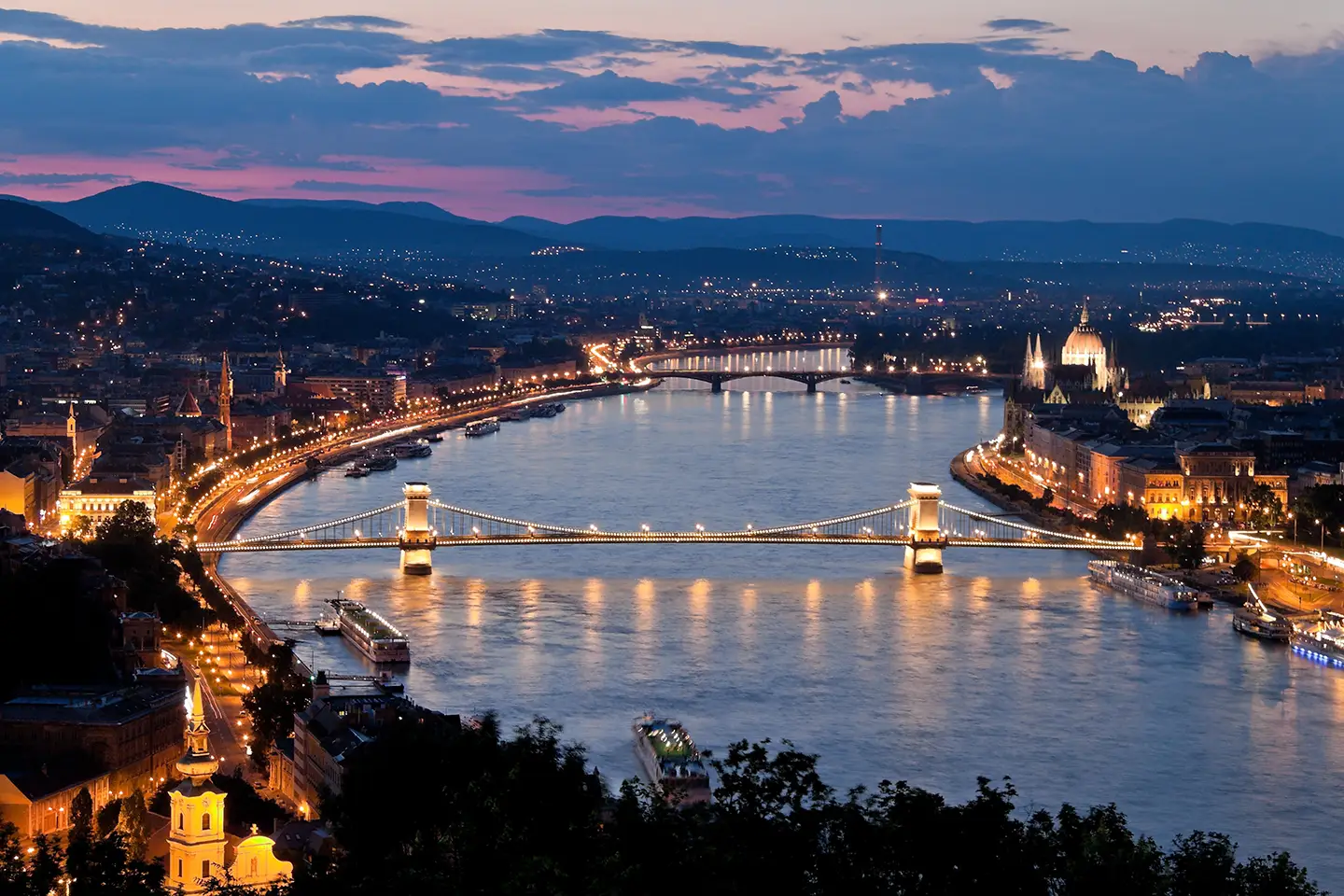 Blick auf die Donau mit beleuchteter Kettenbrücke am Abend währen Budapest Wochenendtrip
