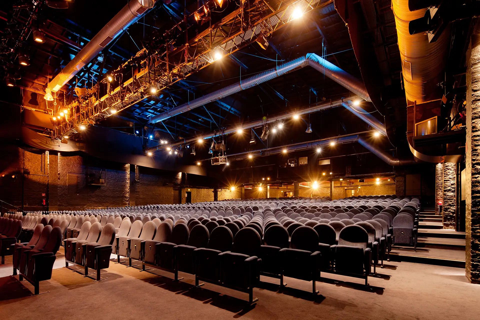 Capitol Theater Düsseldorf: Saal mit dunkelgrauen Stuhlreihen und Industriecharme.