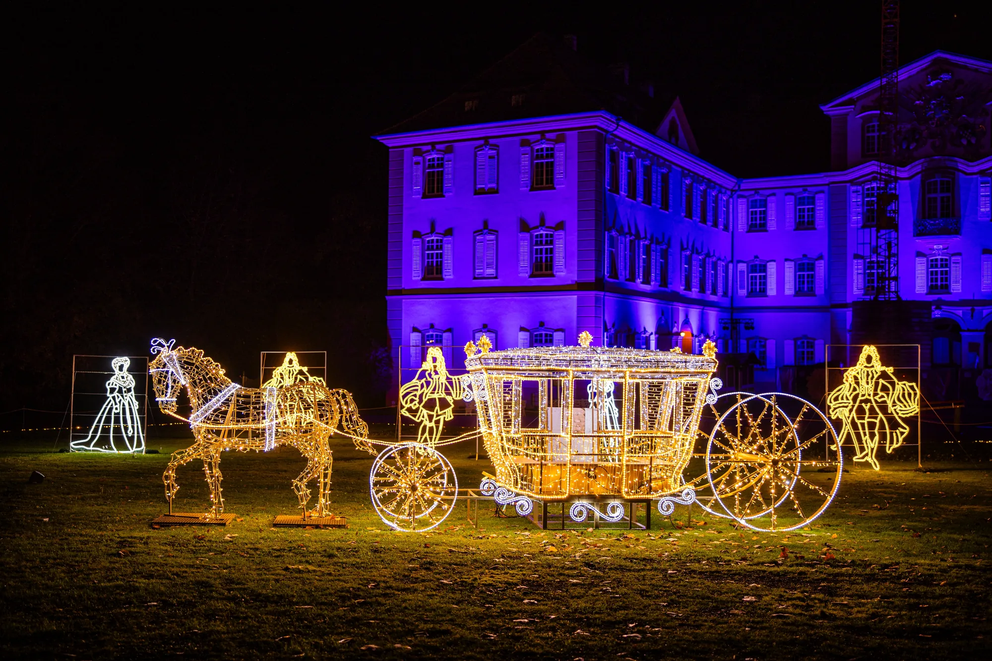 Christmas Garden 2023 - Insel Mainau - Königliche Equipage, Schlitten und Pferd in leuchtenden Drähten bei Nacht, märchenhafte Umgebung