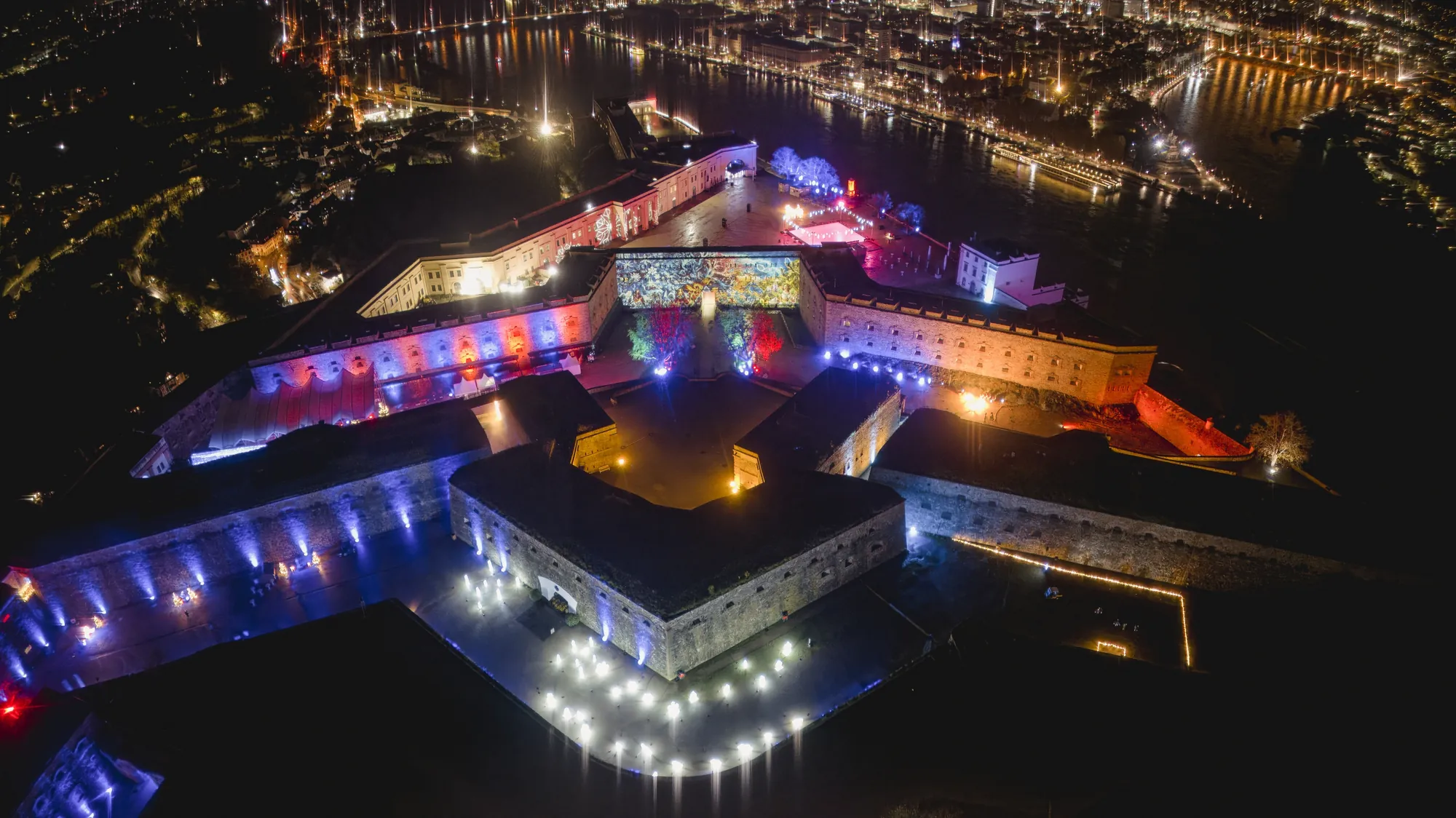 Christmas Garden 2023 - Aussicht auf die Festung Ehrenbreitstein & die Stadt Koblenz von oben bei Nacht mit leuchtenden bunten Effekten
