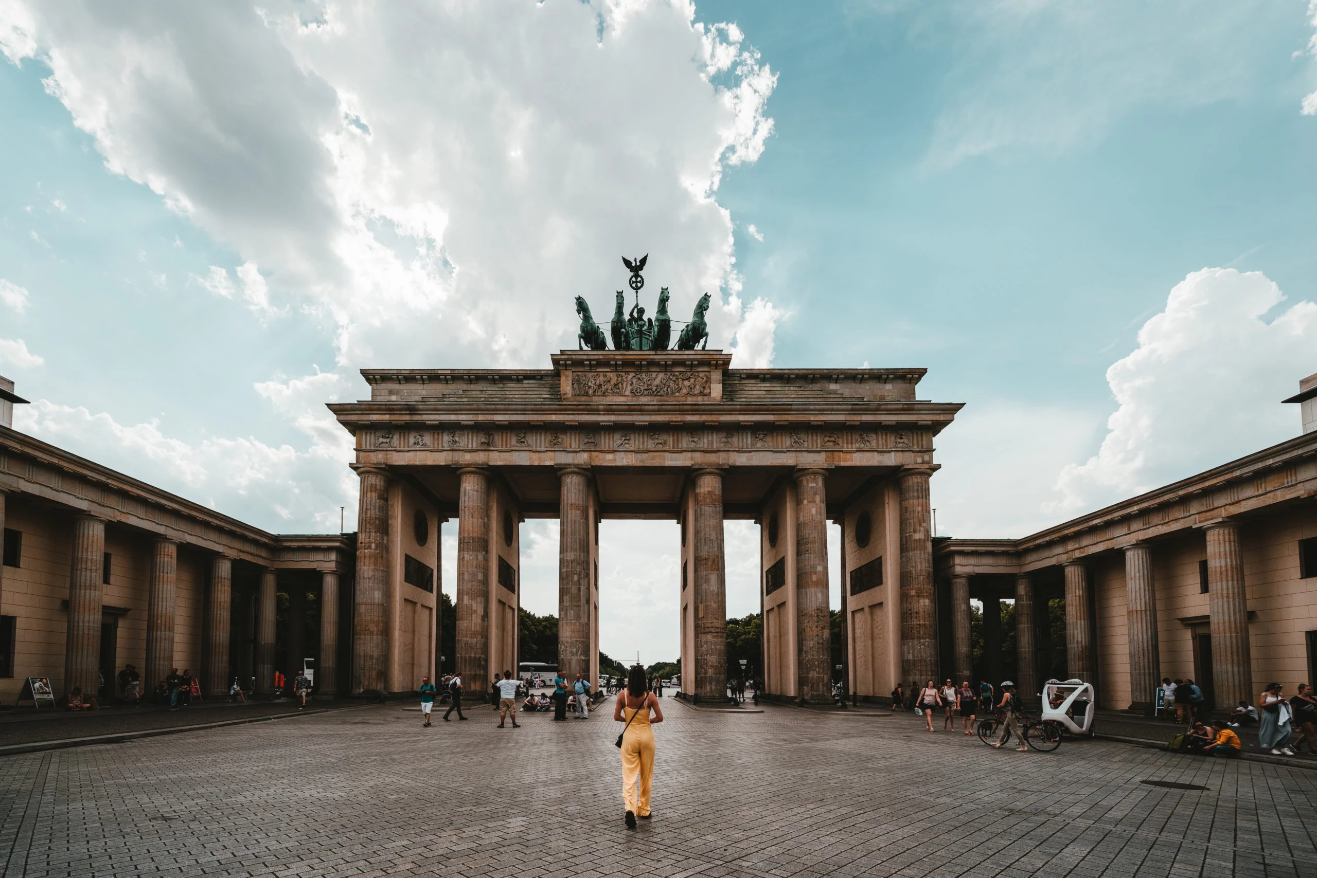 Frau geht auf das Brandenburger Tor in Berlin zu