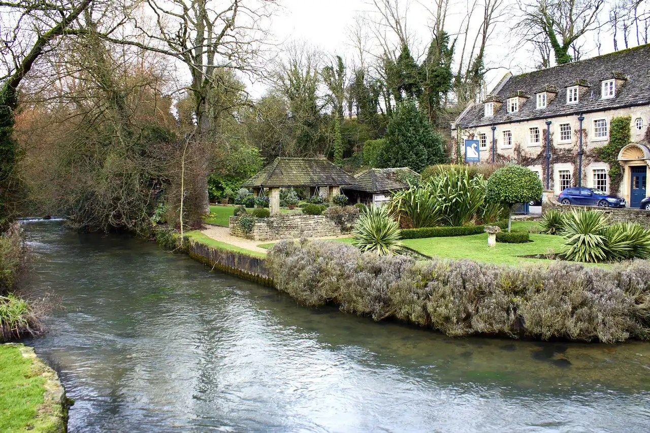 Cotswolds mit Fluss im Vordergrund und Haus im Hintergrund