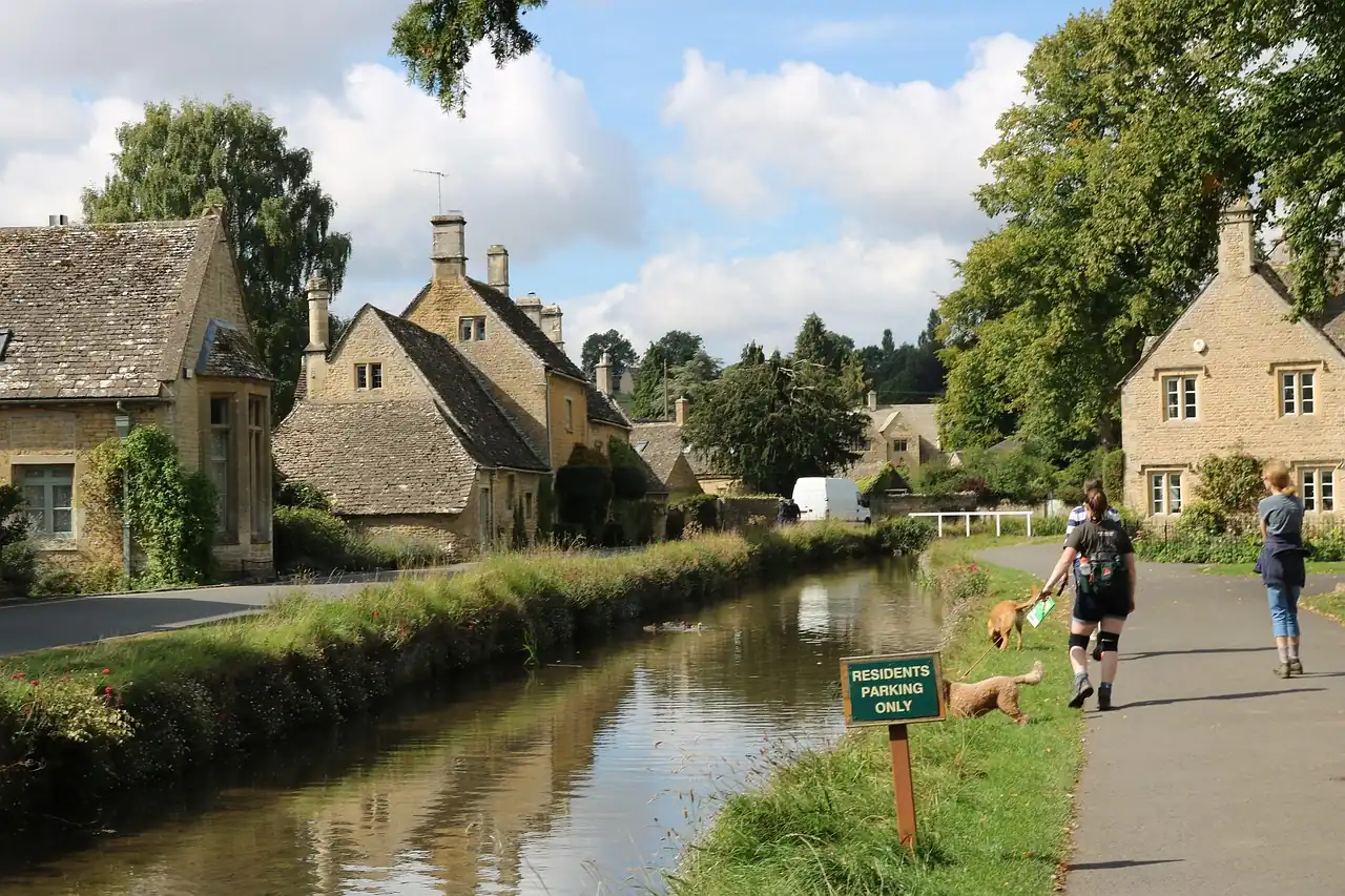 Menschen laufen in Cotswolds am Flussufer entlang