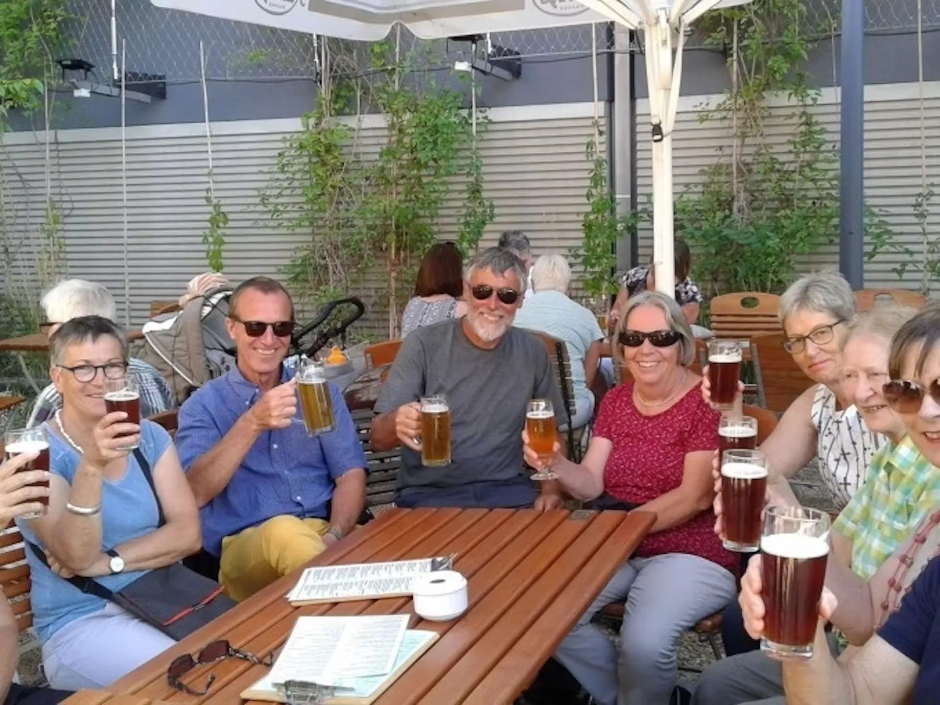 Vergnügte Gruppe genießt ein Bier auf der Terrasse bei einer Craft-Bier Führung