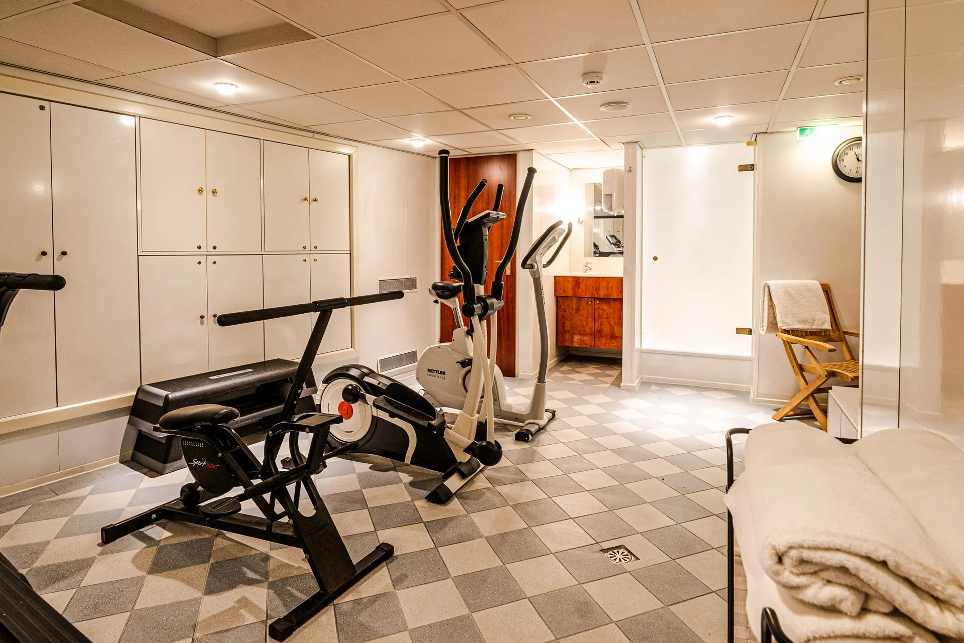 Verschiedene Fitnessgeräte auf Schachbrettmusterboden im Wellnessbereich auf der DCS Amethyst 2