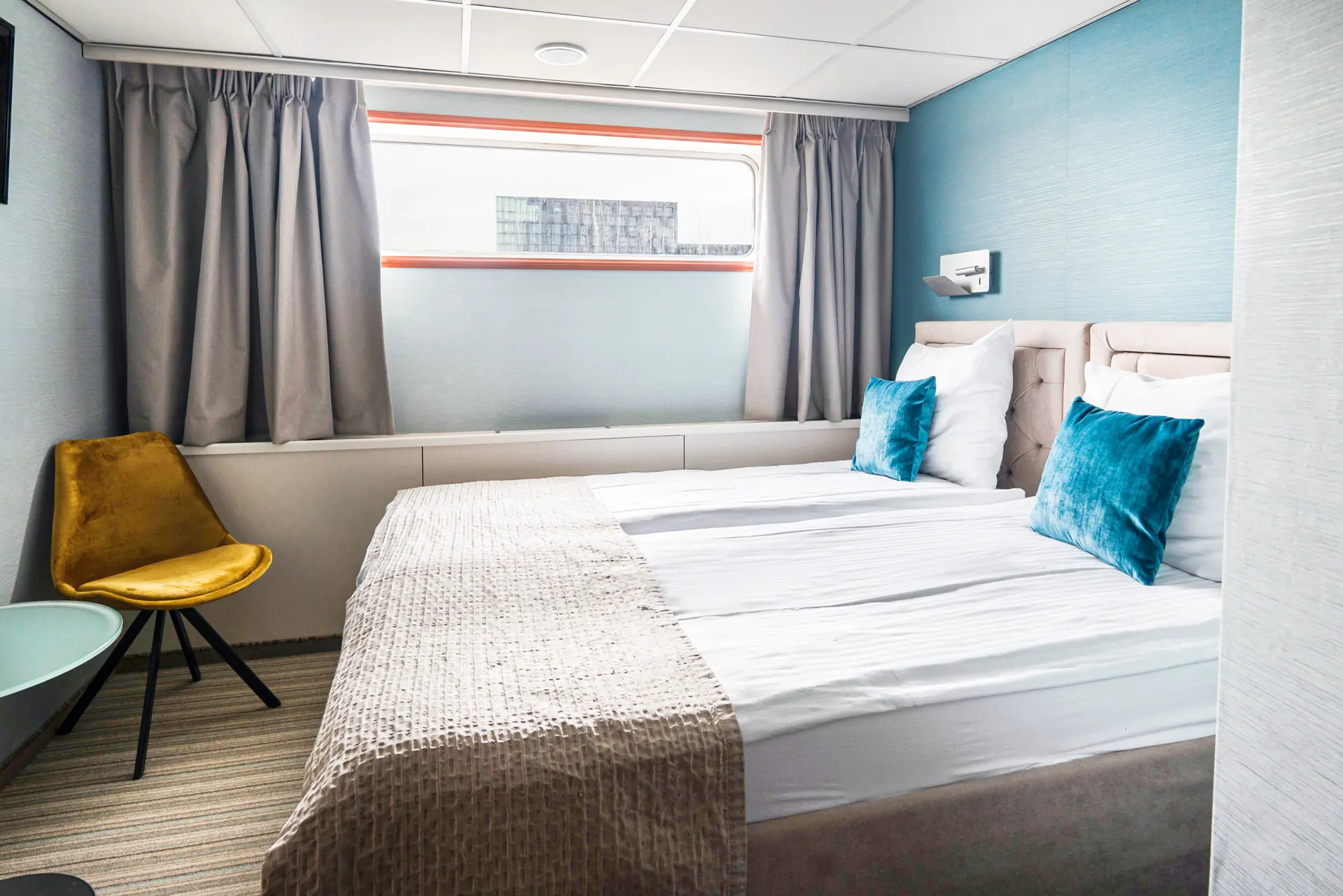 Kabine auf dem Hauptdeck mit Doppelbett und kleinem breitem Fenster an Bord der DCS Amethyst 2