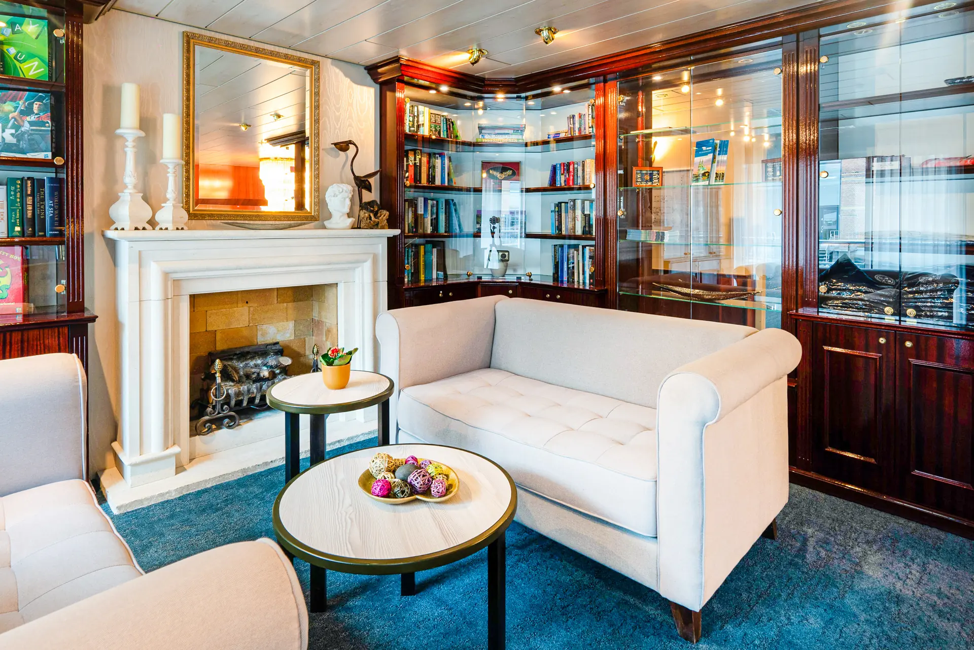 Lobby mit Sitzecke und Kamin im Hintergrund Vitrinen auf der DCS Amethyst 2