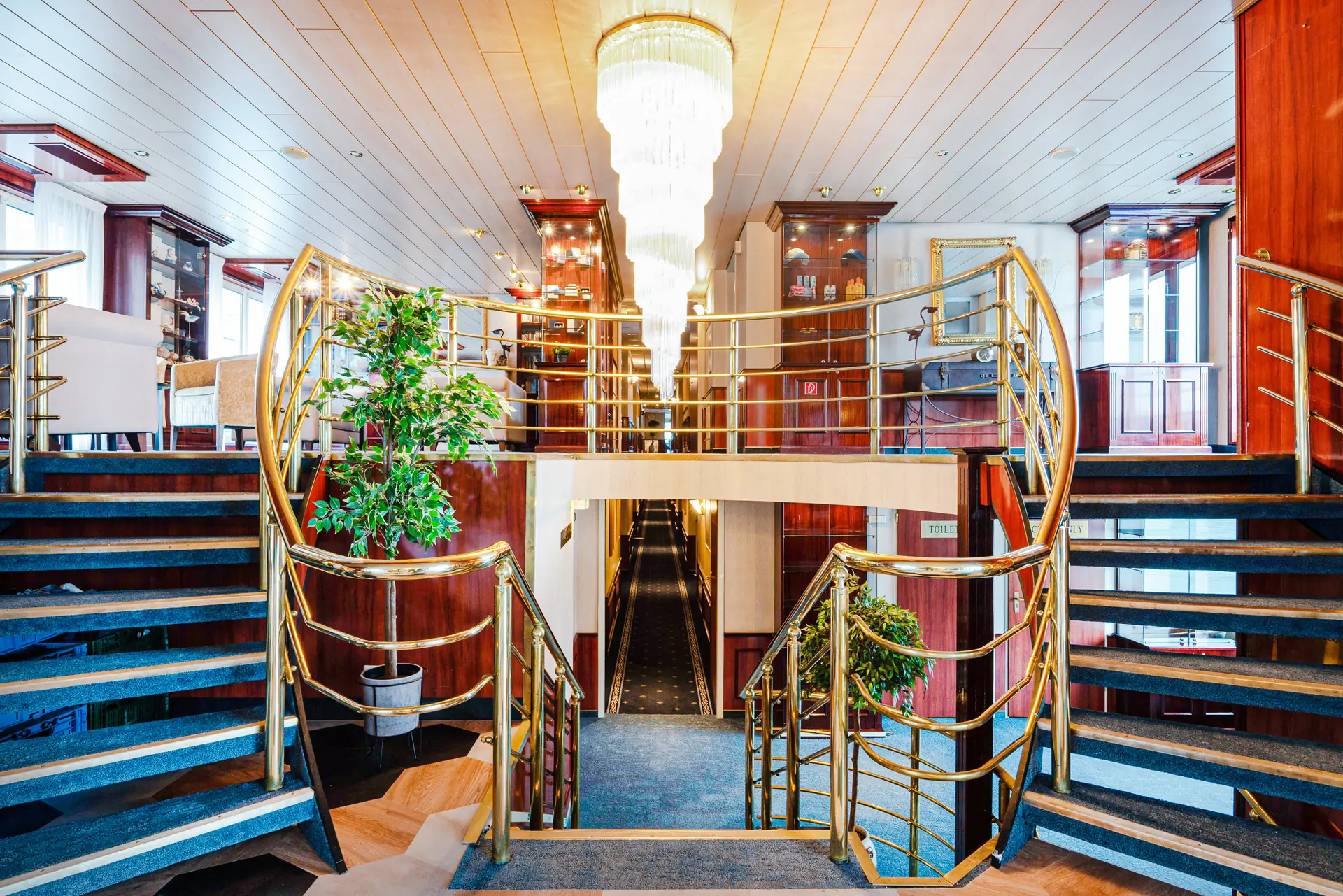 Lobby mit Treppe zu beiden Seiten begehbar und Kronleuchter an der Decke an Bord der DCS Amethyst 2