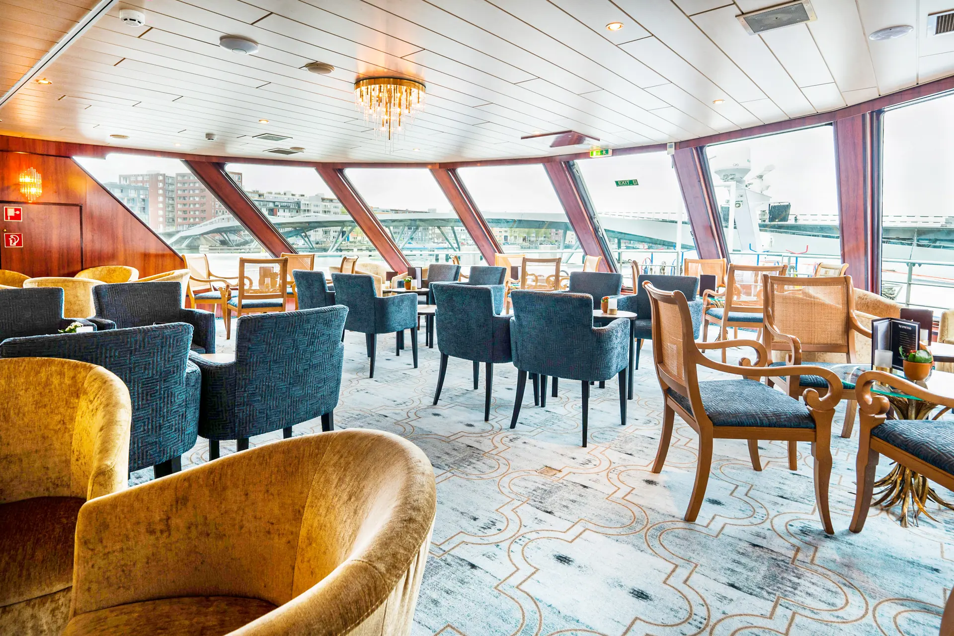 Tische und Stühle in der Panoramalounge mit großer Fensterfront auf der DCS Amethyst 2