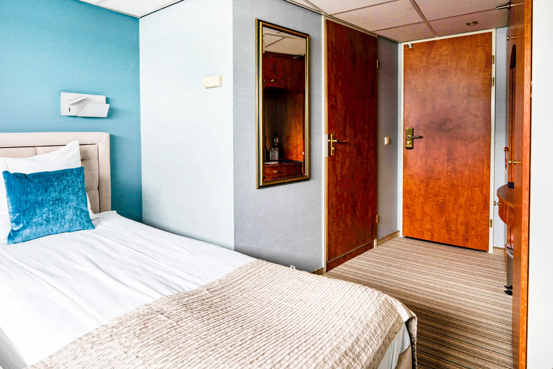 Superior Kabine auf dem Mitteldeck mit Doppelbett und und Blick zur hölzernen Badezimmer- und Kabinentür an Bord der DCS Amethyst 2