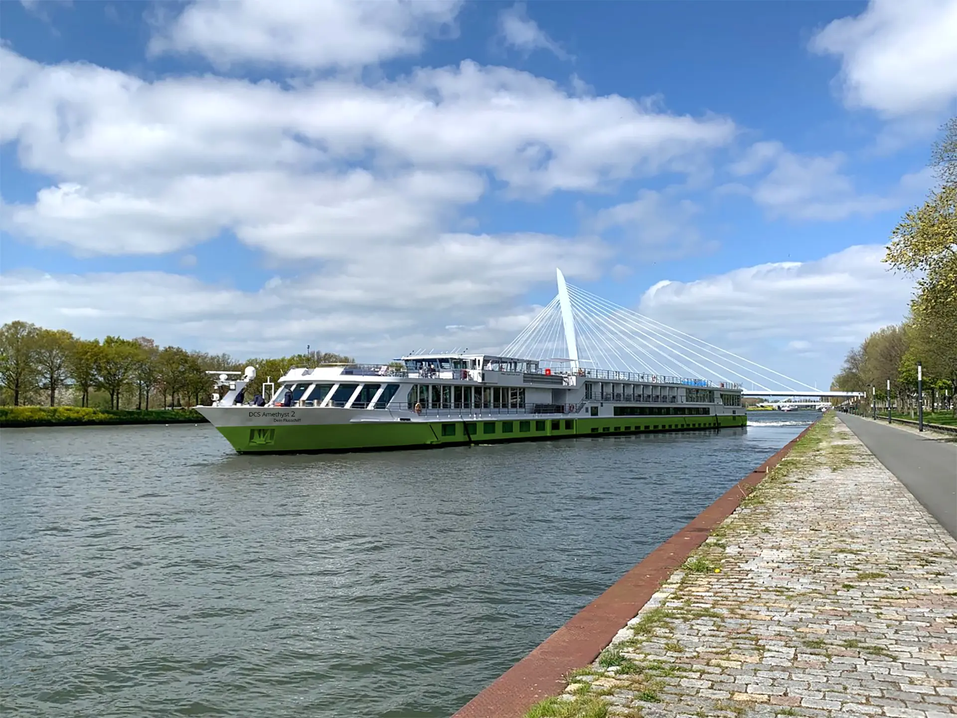 DCS Amethyst 2, Außenansicht von der Seite auf dem Fluss mit weißer Brücke im Hintergrund