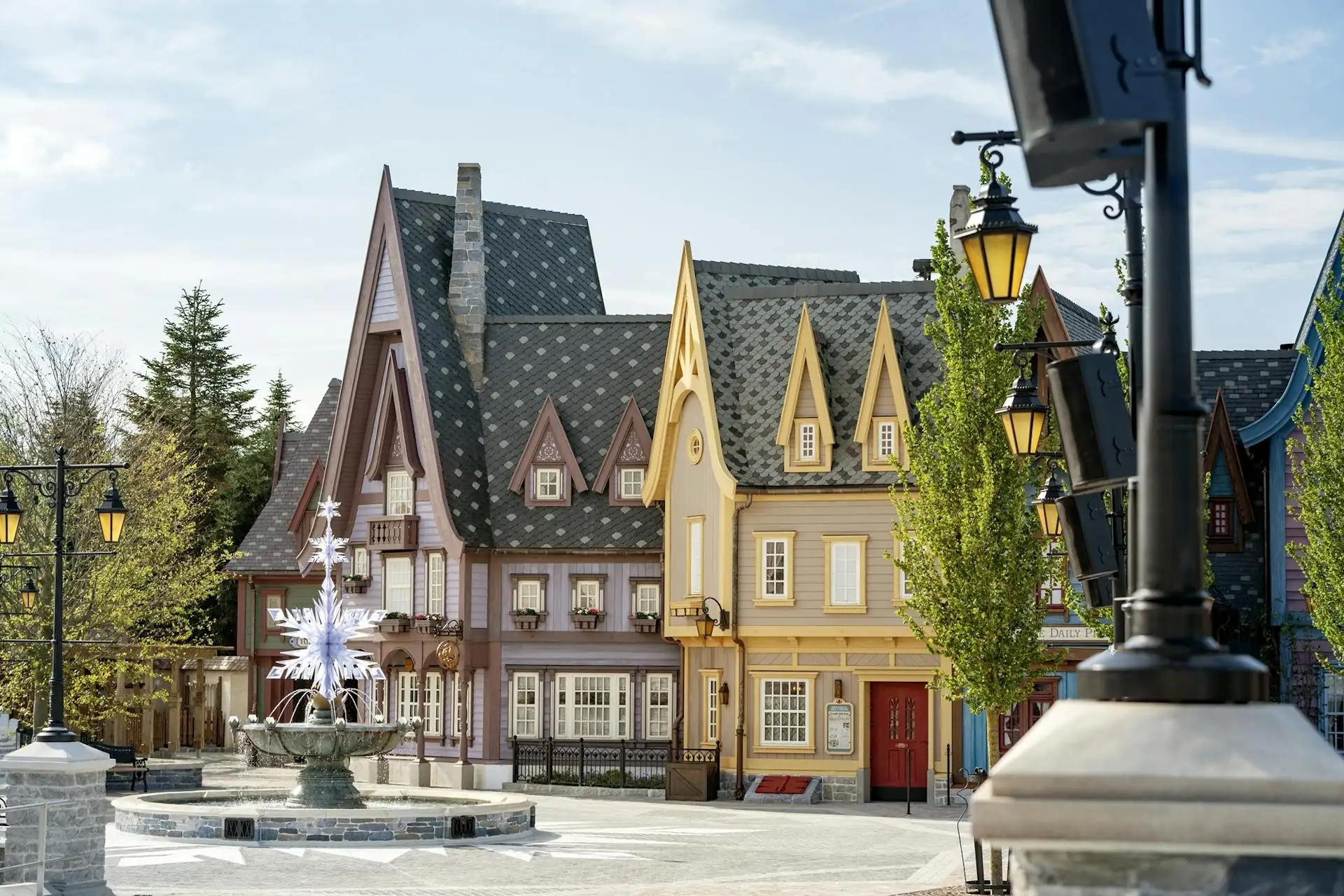 Fachwerkhäuser im Stil eines europäischen Dorfes mit spitzen Dächern und einer Brunnenanlage im Vordergrund in Disneyland Paris