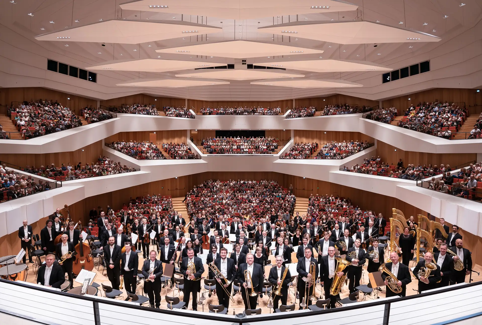 Dresdner Philharmonie im Konzertsaal, Musiker mit Instrumenten vor vollem Publikum auf drei Rängen