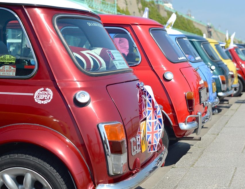Rote Mini Cooper in einer Reihe bunter Mini Cooper, Heckansicht, Union Jack Flagge an der Stoßstange
